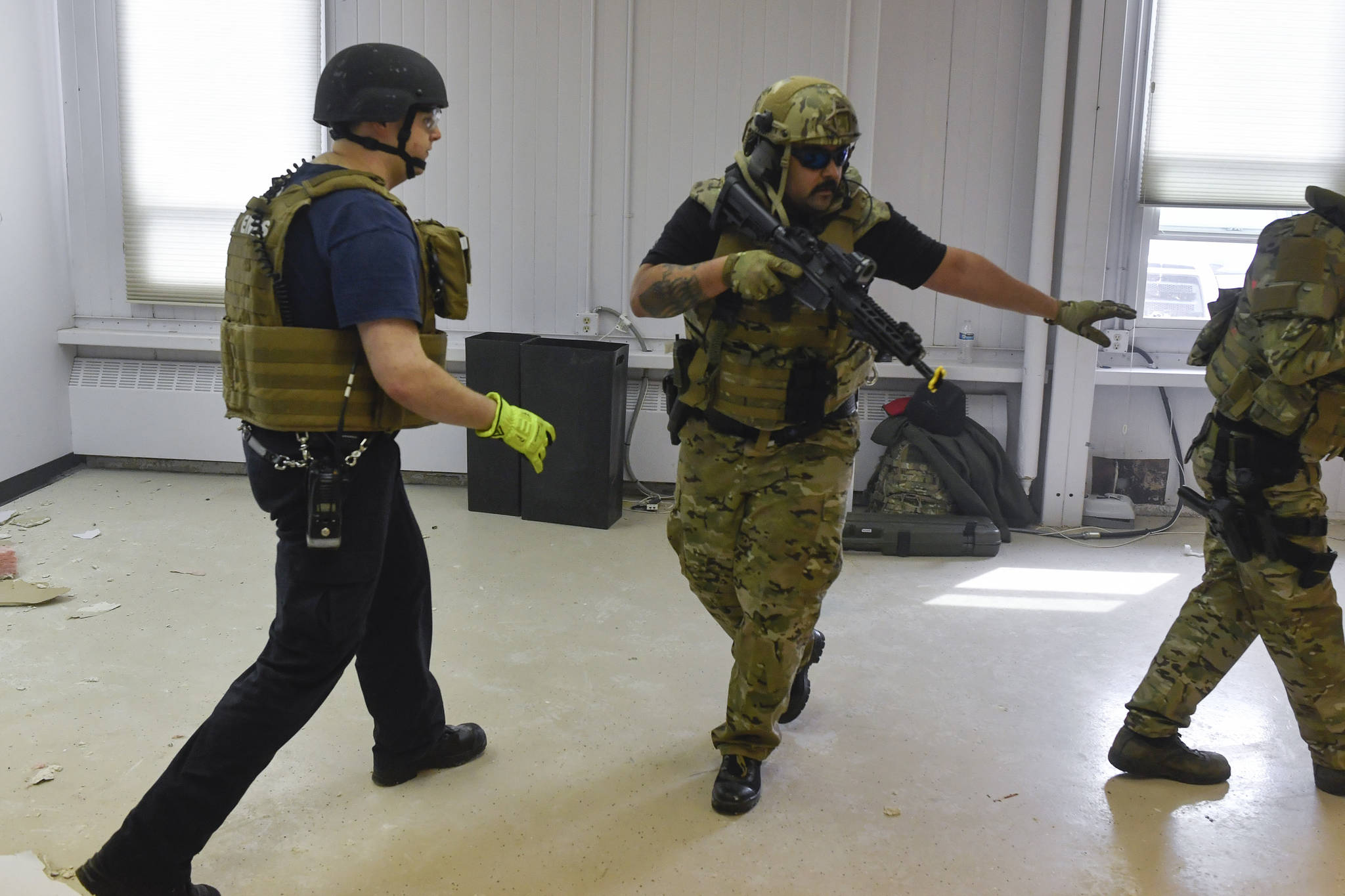 Juneau Police Department Officer Nick Garza, right, escorts Cory Hutchinson, of Capital City Fire/Rescue, as they conduct a joint training exercise at the former Public Safety Building on Whittier Street on Tuesday, April 16, 2019. The training is designed to boost collaboration between CBJ law enforcement and emergency medical personnel. (Michael Penn | Juneau Empire)