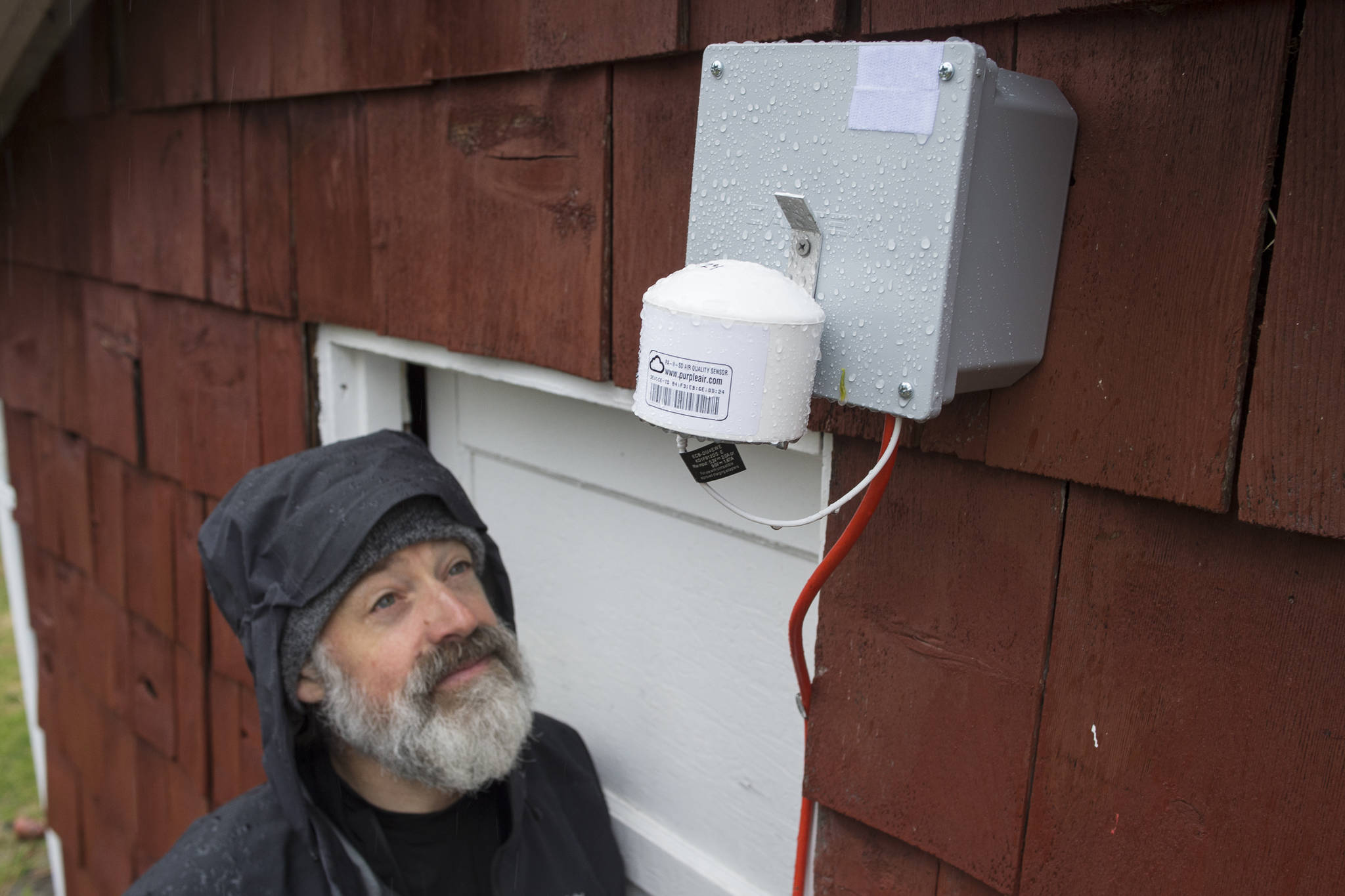 Mike Hekkers looks at an air quality measurement device that was installed by the Department of Environmental Conservation at his downtown Juneau home on Thursday, April 18, 2019. The device, along with a number of others, will measure air quality in downtown during this summer’s cruise ship season. (Michael Penn |Juneau Empire)