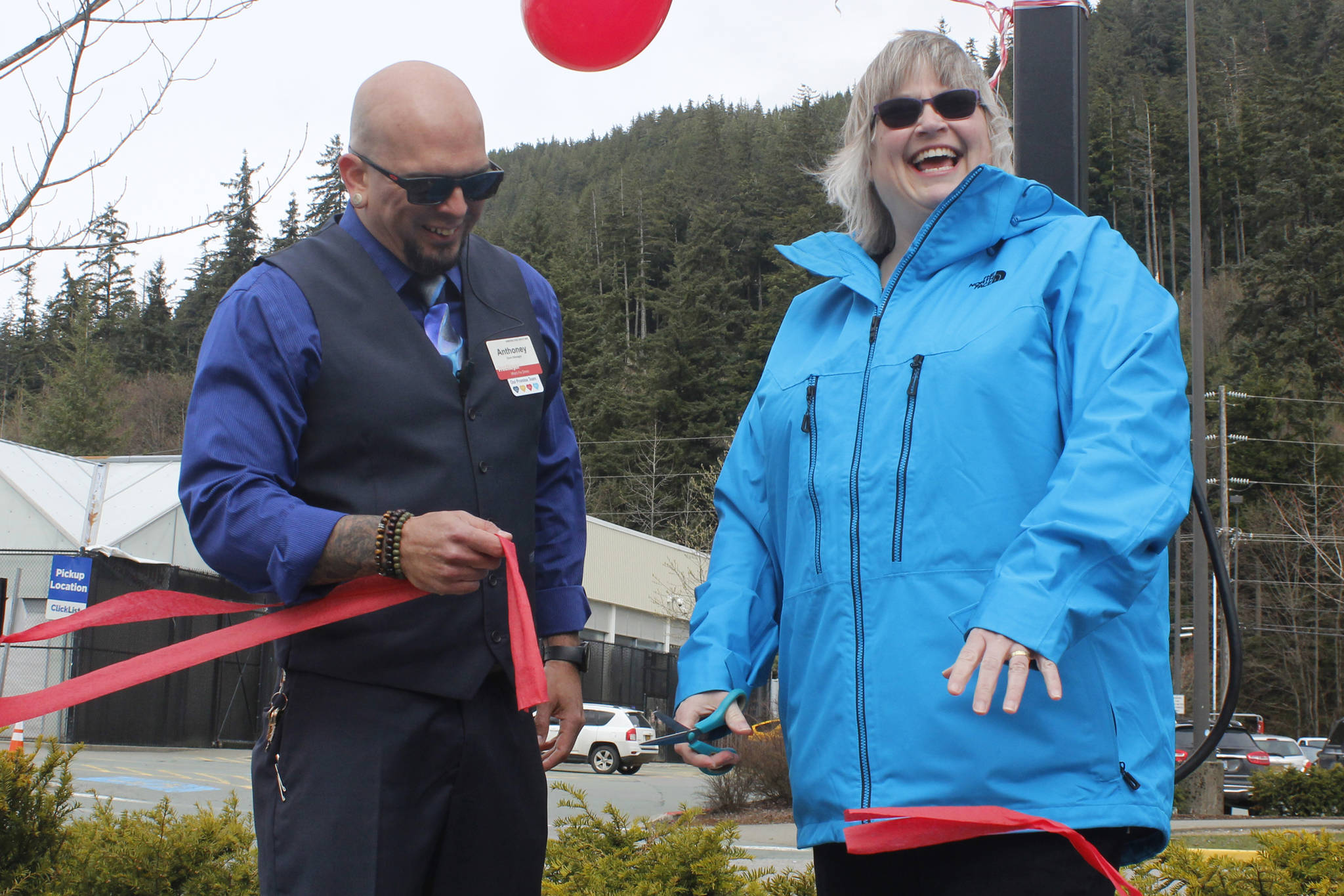 Juneau Mayor Beth Weldon laughs as she and Fred Meyer Store Manager Anthoney Gurule cut a ribbon unveiling four new electric vehicle chargers at Fred Meyer on Saturday, April 20, 2019. (Alex McCarthy | Juneau Empire)