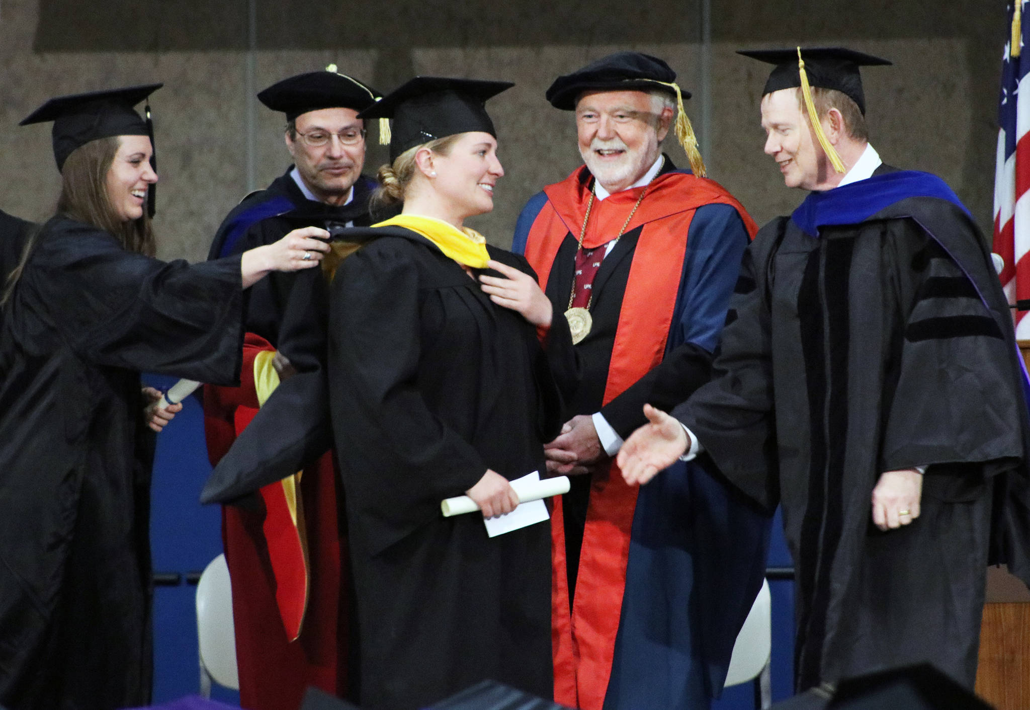 University of Alaska Southeast Chancellor Richard Caulfield, second from right, congratulates a graduate during Sundays commencement ceremony at the UAS Recreation Center. UAS awarded 399 associate, bachelor and masters degrees, 97 certificates and professional licensures, and 223 occupational endorsements this year. (Erin Laughlin | For the Juneau Empire)