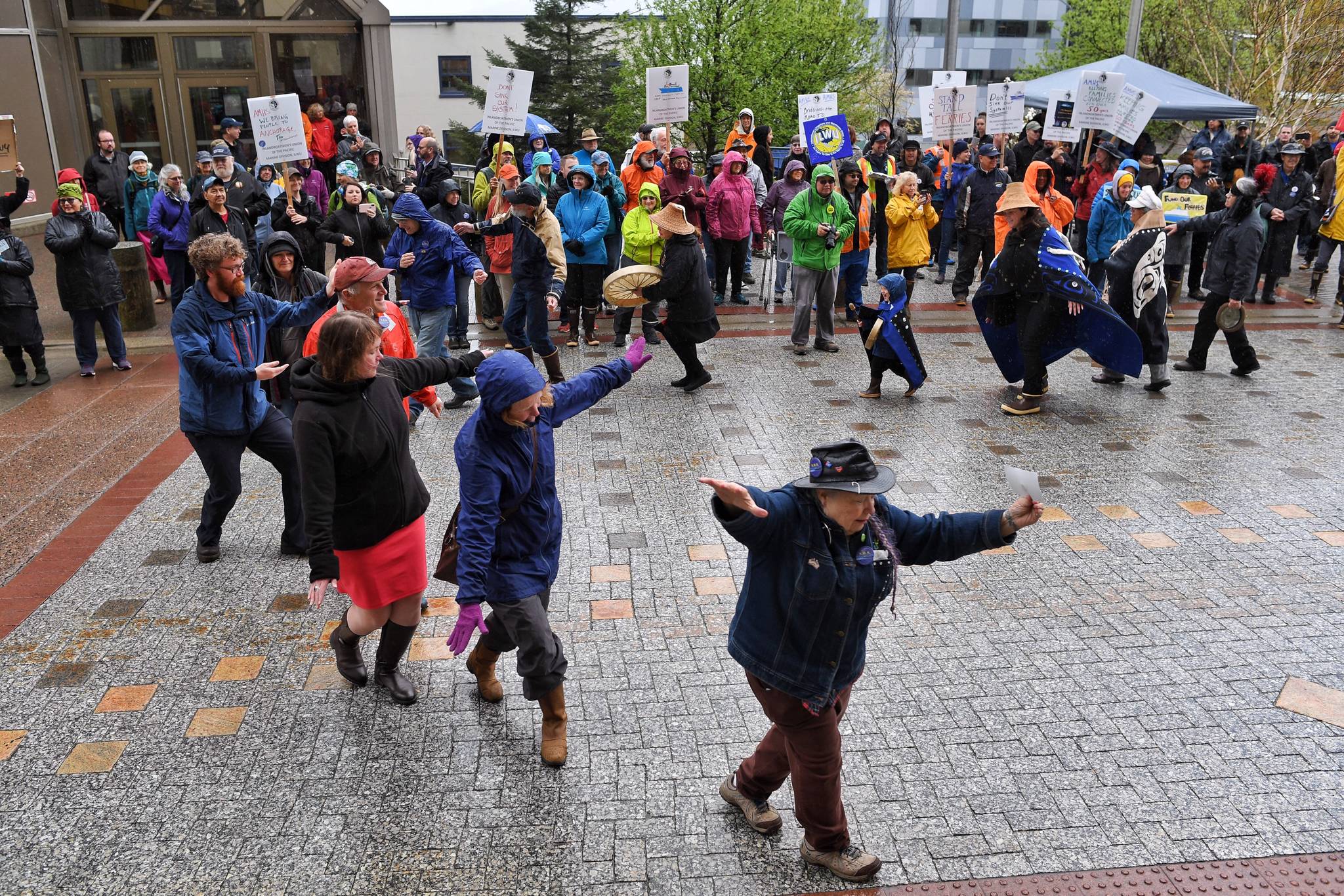 Attendees, including Rep. Sara Hannan, D-Juneau, join Nancy Barnes from Yees Ku Oo for a song and dance in front of the Capitol. (Michael Penn | Juneau Empire)