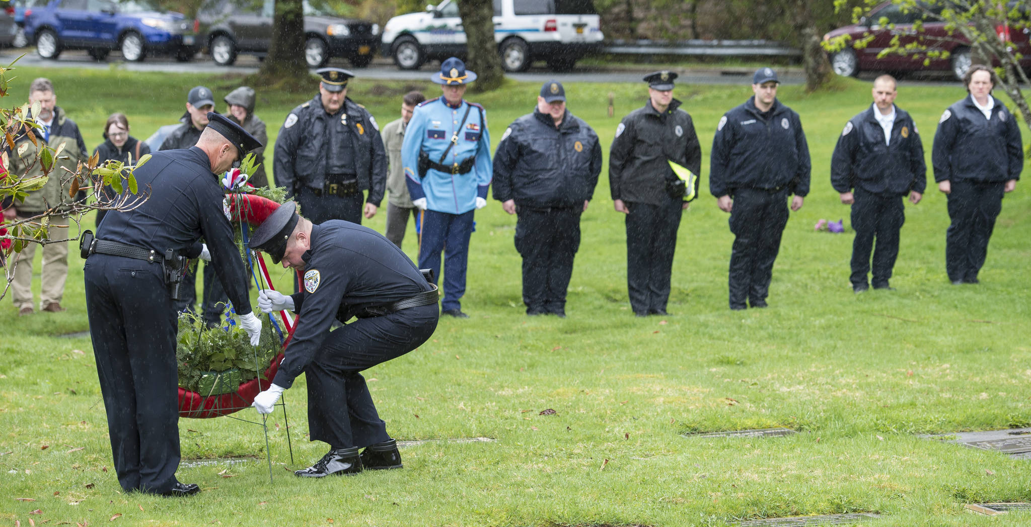 In this May 11, 2018 photo, Juneau Police Department Officers Michael Wise, left, and Jeff Brink place a wreath in front of the grave of Officer Richard James Adair at Evergreen Cemetery as part of Alaska’s Police Memorial Ceremonies. Juneau Police Department officers Adair and Jimmy Earl Kennedy died in the line of duty on April 17, 1979. (Michael Penn | Juneau Empire File)