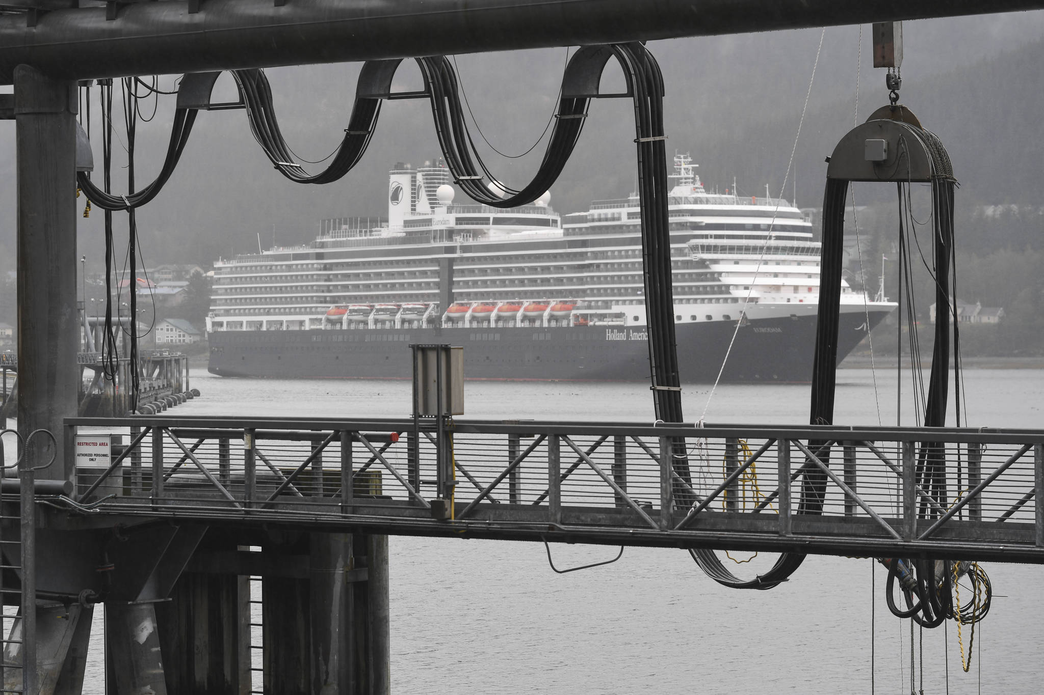 The Holland America Line Eurodam pulls into Juneau’s downtown harbor heading for the city-owned dock on Monday, May 6, 2019. The privately owned South Franklin Dock, foreground, is currently the only dock set up to provide electric power to a ship while at berth in Juneau. (Michael Penn | Juneau Empire)