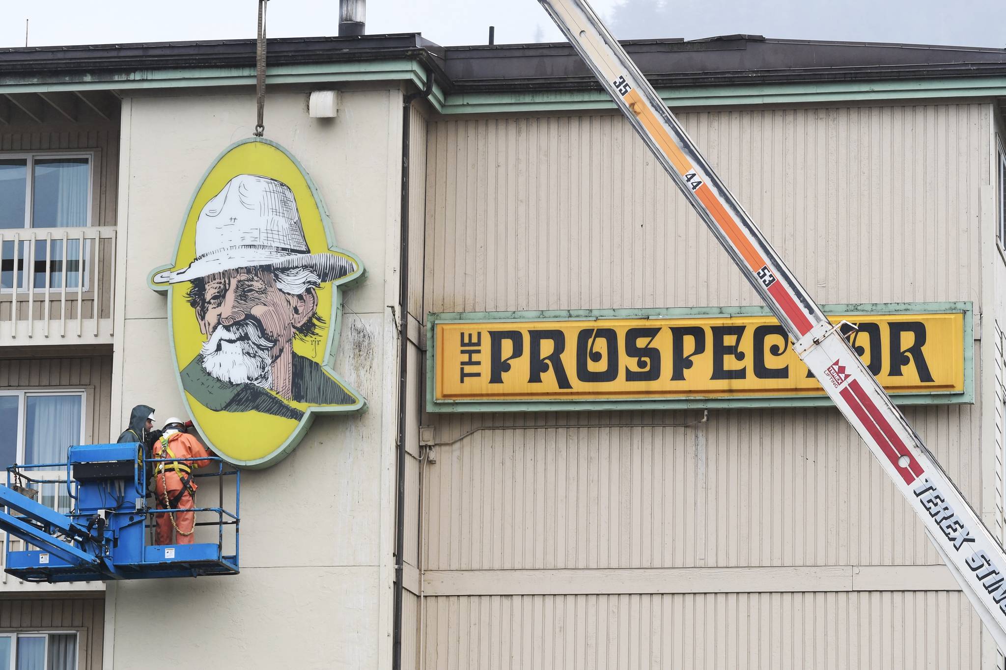 A Juneau Electric crew takes down signage at The Prospector hotel on Wednesday, May 8, 2019. (Michael Penn | Juneau Empire)