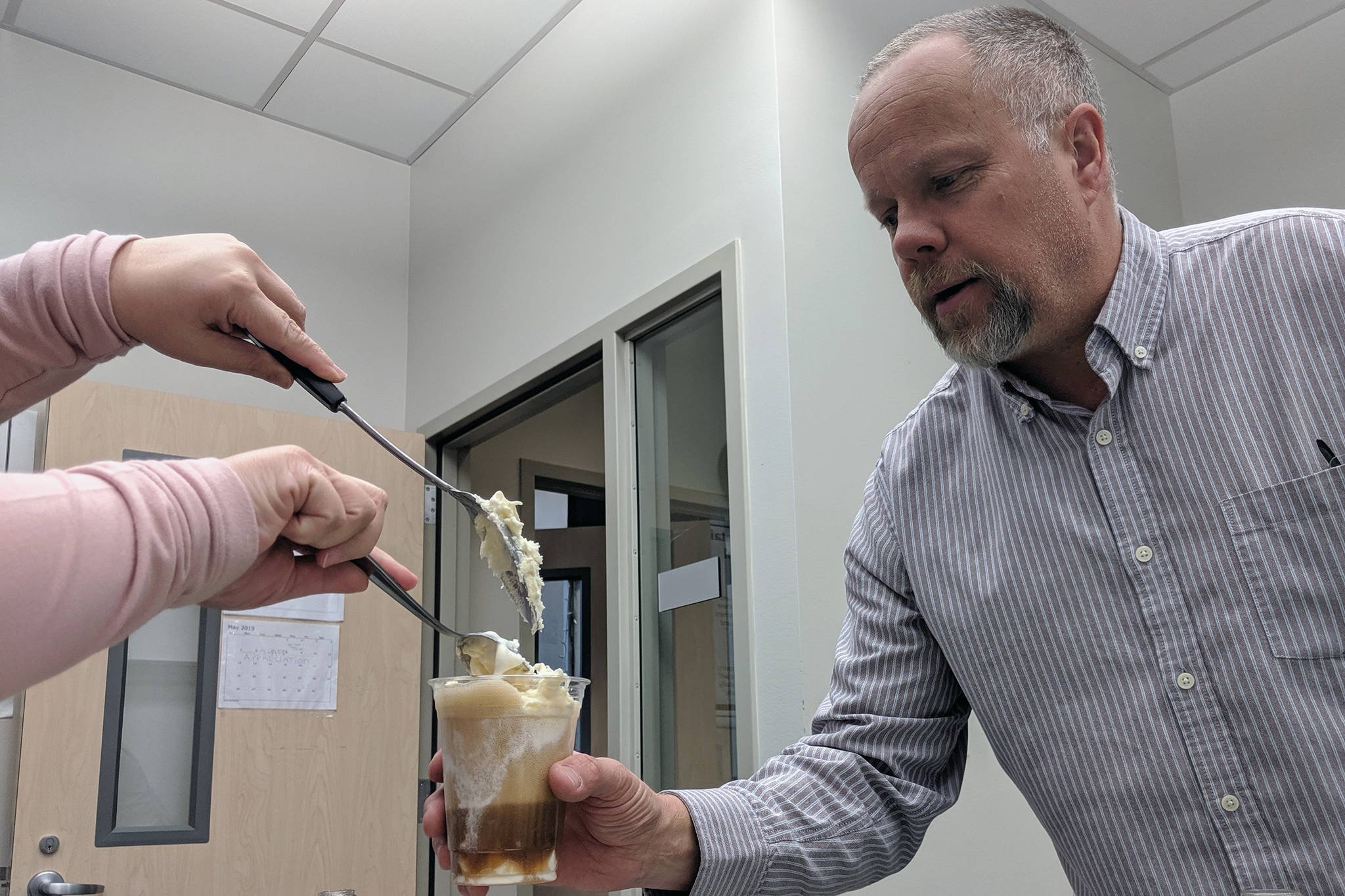Chris Peterson, a special education teacher, gets another scoop of ice cream added to his root beer float during Teacher Appreciation Week on Friday, May 10, 2019. (Ben Hohenstatt | Juneau Empire)