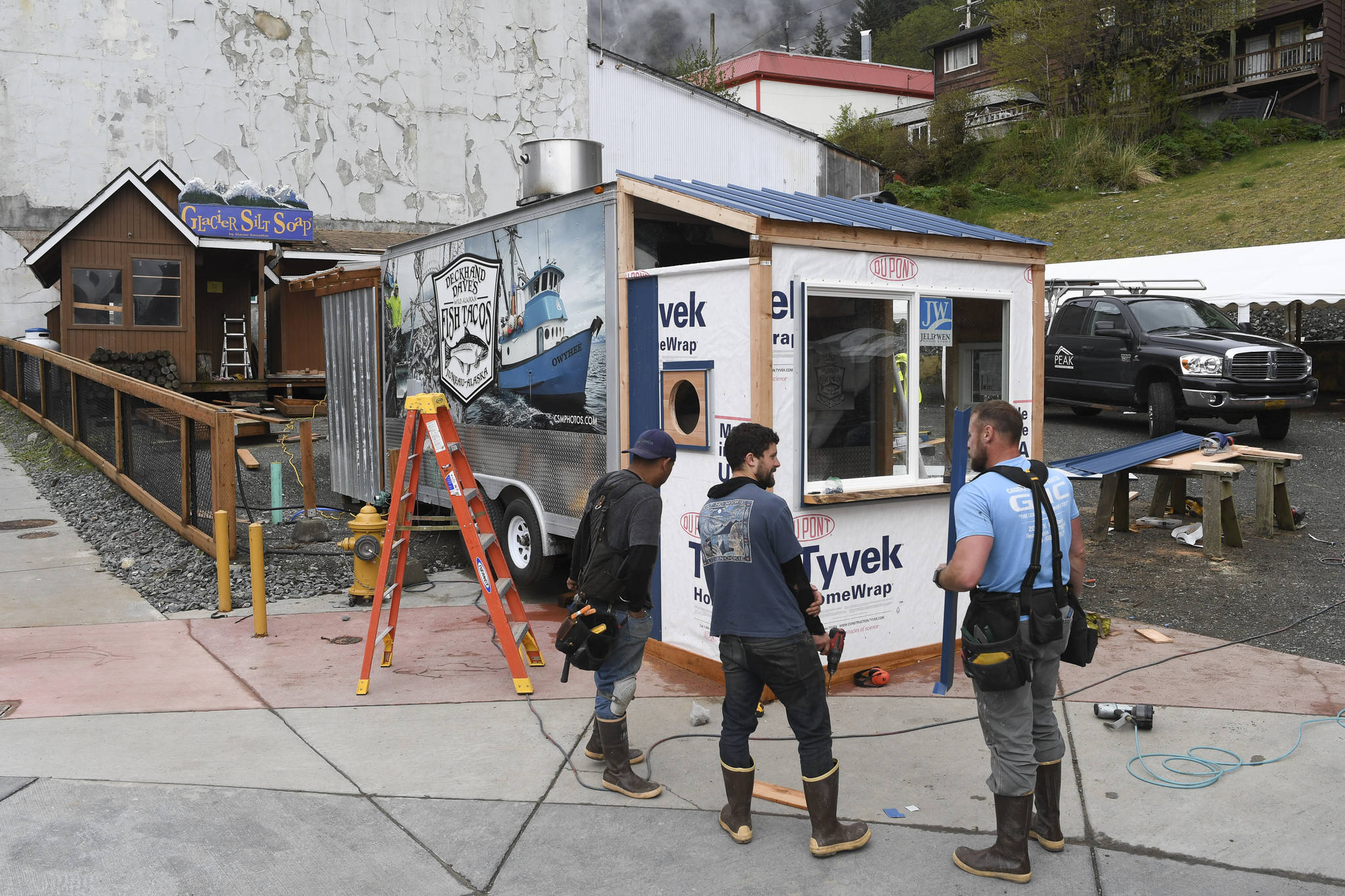 Dave McCasland, owner of Deckhand Dave’s Fish Tacos, center, talks with Eric Plummer, left, and Brennen Brewer, of Peak Construction, as they set up food truck businesses at Gunakedeit Park, also known as Pocket Park, on Thursday, May 9, 2019. The businesses are expected to be open by Monday. (Michael Penn | Juneau Empire)