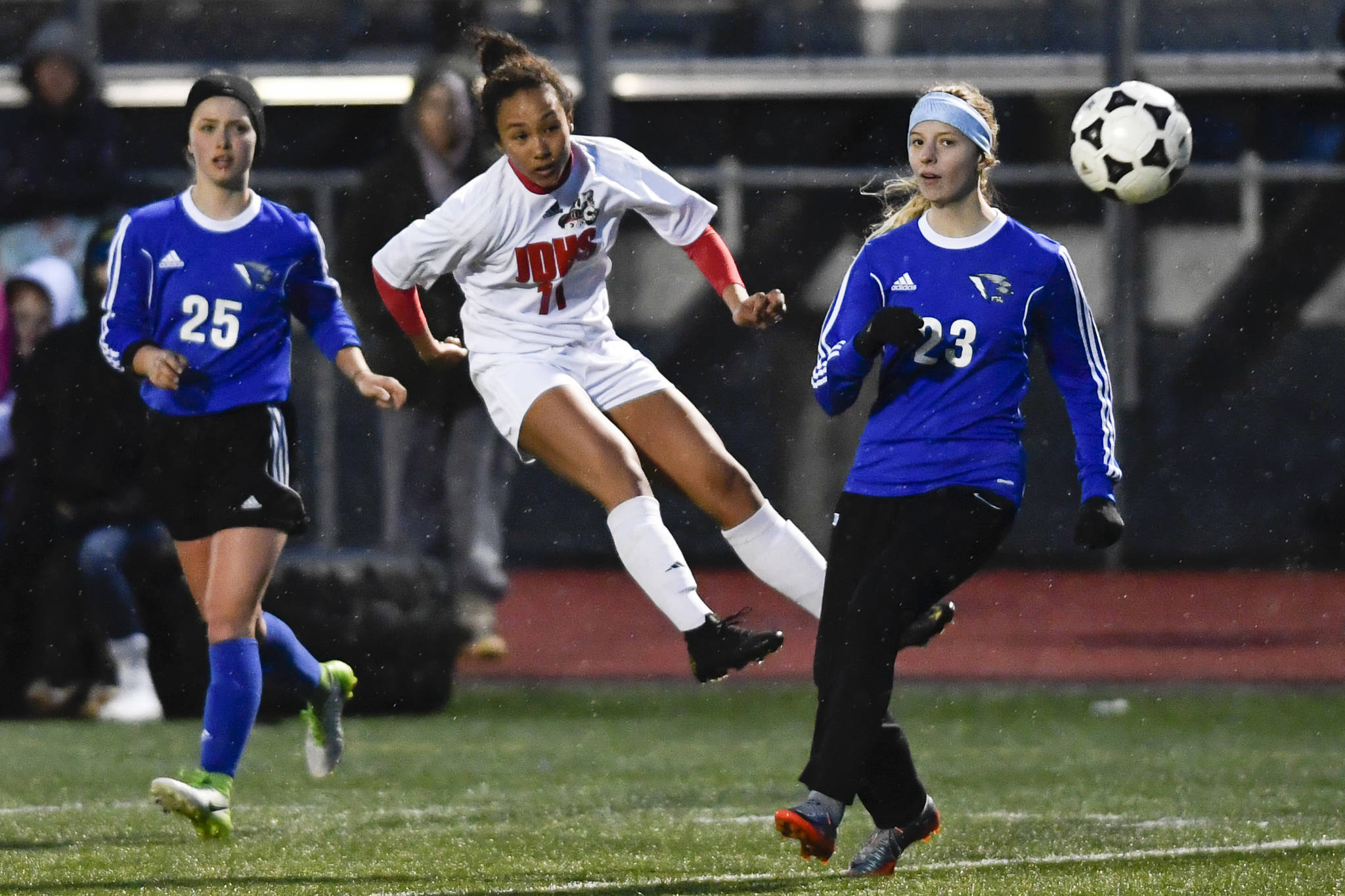 Juneau-Douglas Malia Miller, center, fires a shot toward the goal between Thunder Mountains Kiah Dihle, left, and Isabella Hanna at TMHS on Wednesday, April 17, 2019. (Michael Penn | Juneau Empire File)
