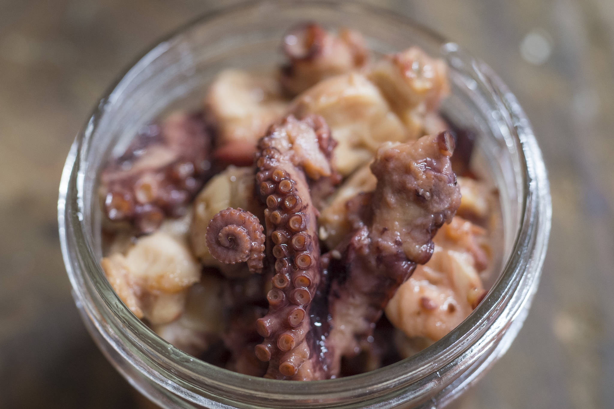 Rik Pruett said it has been a dream come true to bring his smoked octopus to market. (Michael Penn | Juneau Empire)