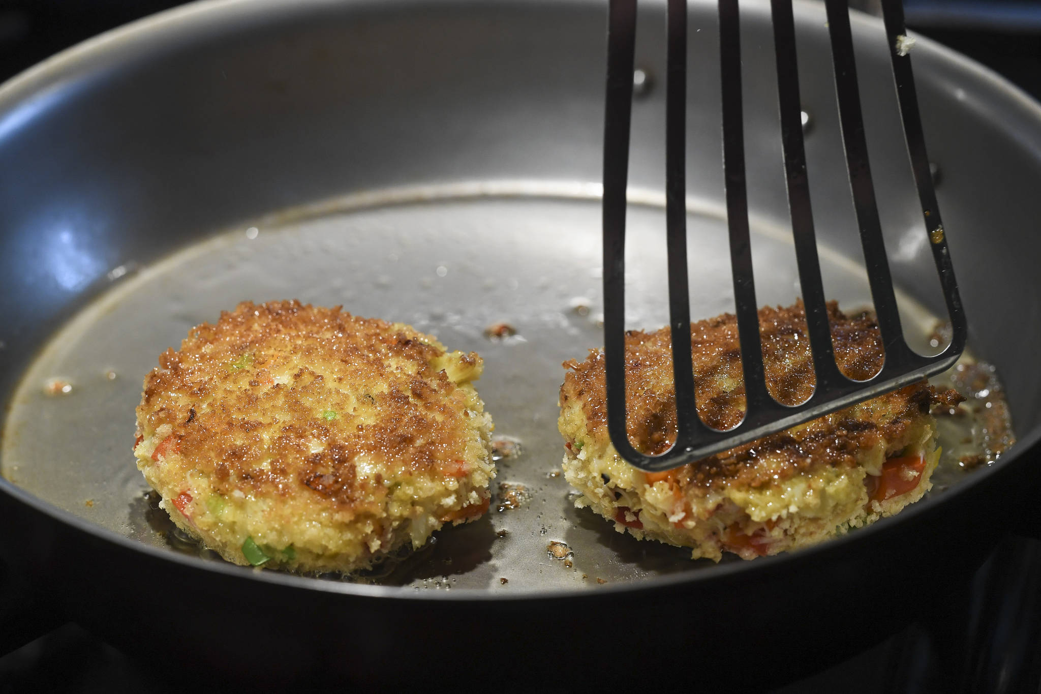 Erin Anais Heist prepares crab cakes to go with a twisted stalk salad on Friday, May 10, 2019. (Michael Penn | Juneau Empire)