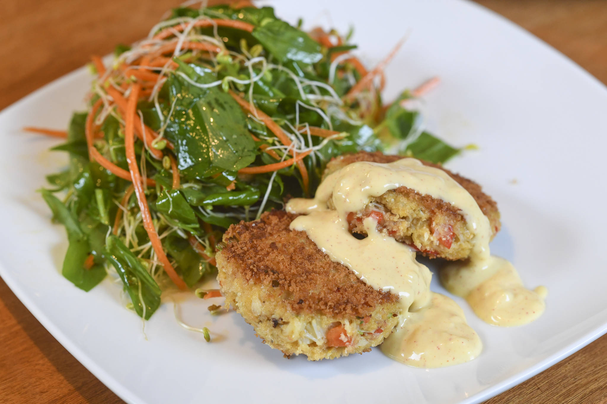 Erin Anais Heist prepares crab cakes with a twisted stalk salad on Friday, May 10, 2019. (Michael Penn | Juneau Empire)