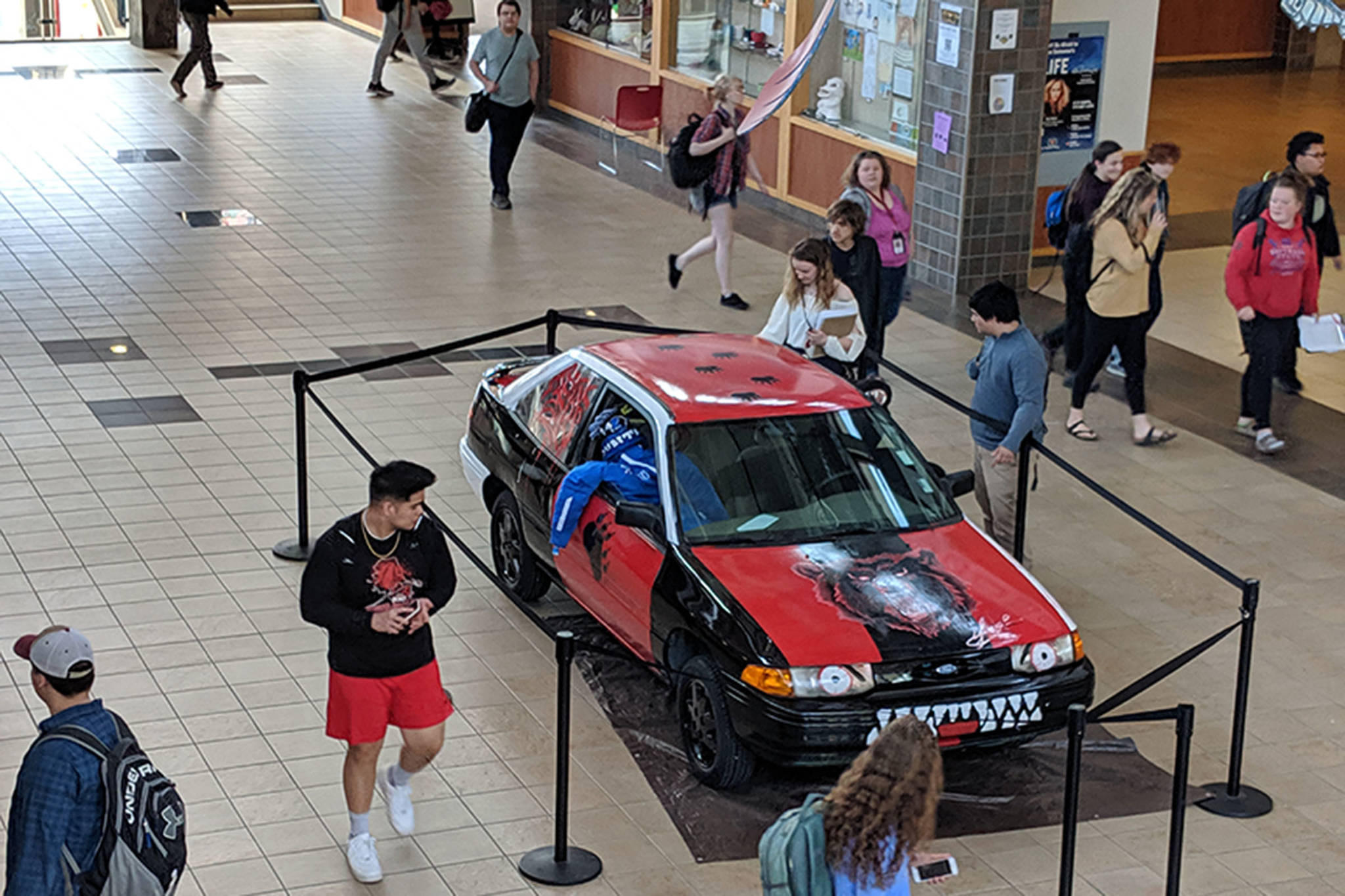 Students look at a car located in the Juneau-Douglas High School: Yadaa.at Kalé commons, May 13, 2019. While the car is an apparent senior prank, it did not cause damage to any property or prove to be a nuisance, administrators said. (Ben Hohenstatt | Juneau Empire)