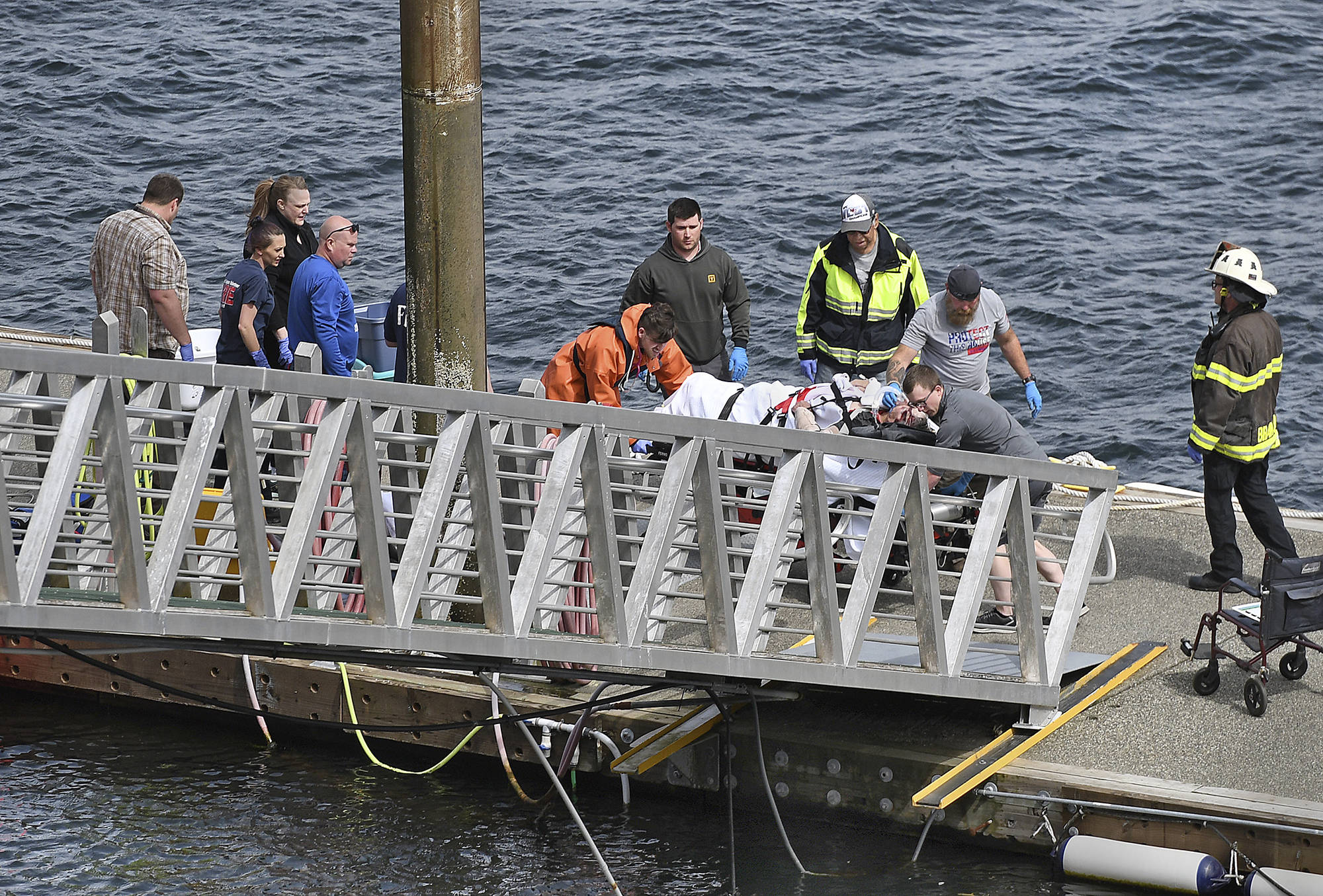 Emergency response crews transport an injured passenger to an ambulance at the George Inlet Lodge docks, Monday, May 13, 2019, in Ketchikan, Alaska. The passenger was from one of two float planes reported down in George Inlet early Monday afternoon and was dropped off by a U.S. Coast Guard 45-foot response boat. (Dustin Safranek | Ketchikan Daily News via AP)