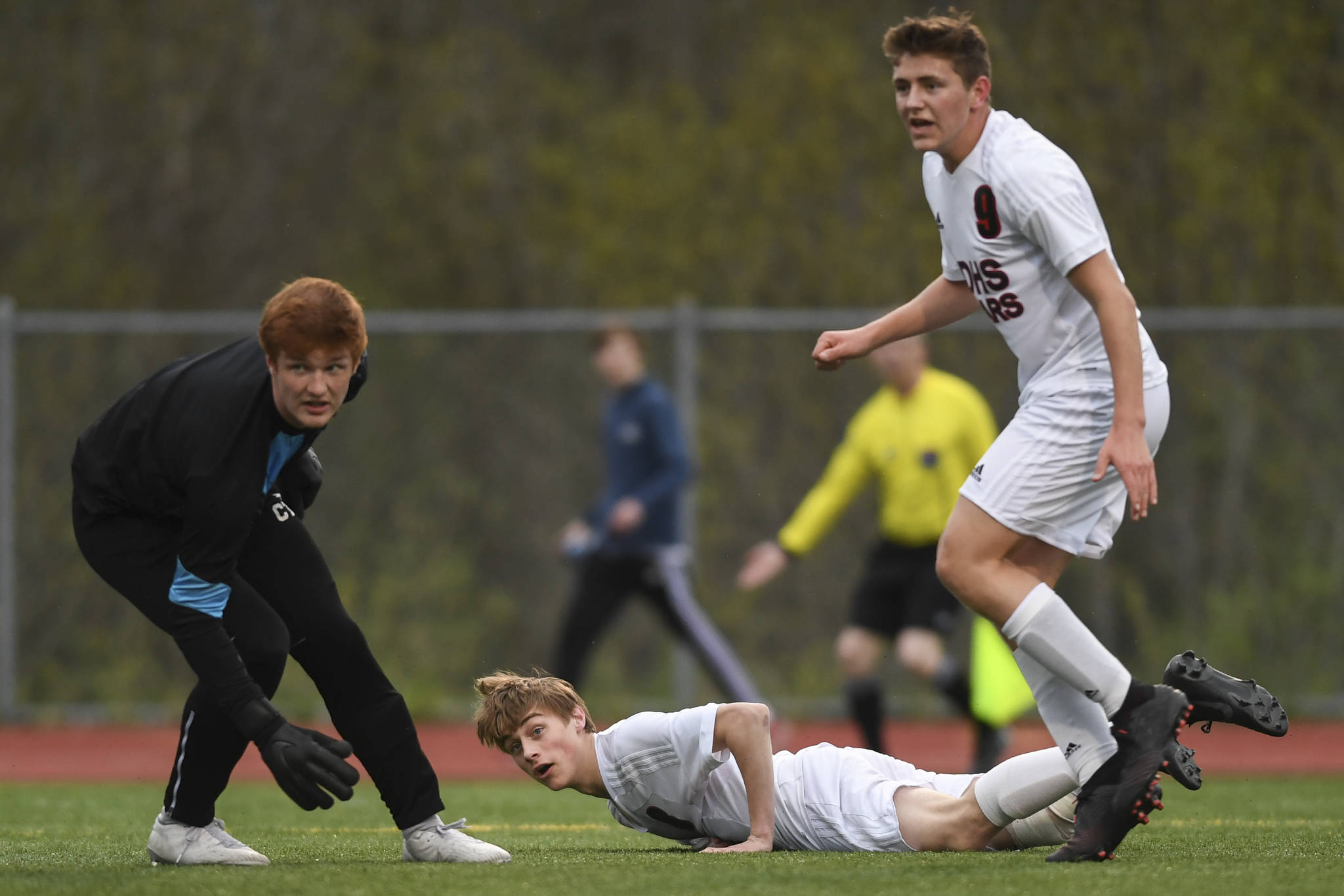 Juneau-Douglas Koby Goldstein, center, watches his goal shot get by Thunder Mountains goalkeeper Caleb Traxler at TMHS on Tuesday, May 14, 2019. JDHS won 5-1. (Michael Penn | Juneau Empire)