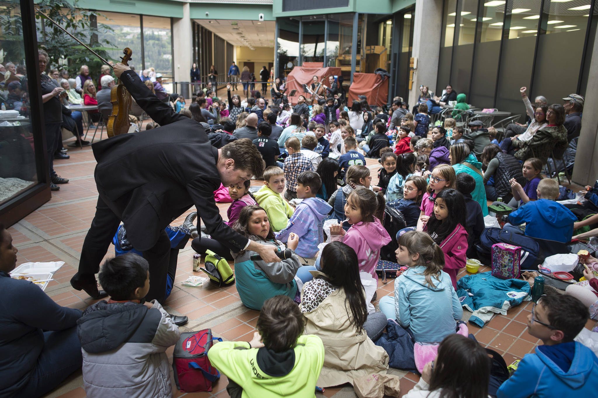 Violinist Jason Issokson wades into a sea of elementary school students to take questions as the Argus String Quartet plays a Brown Bag Concert at the State Office Building on Wednesday, May 15, 2019. (Michael Penn | Juneau Empire)