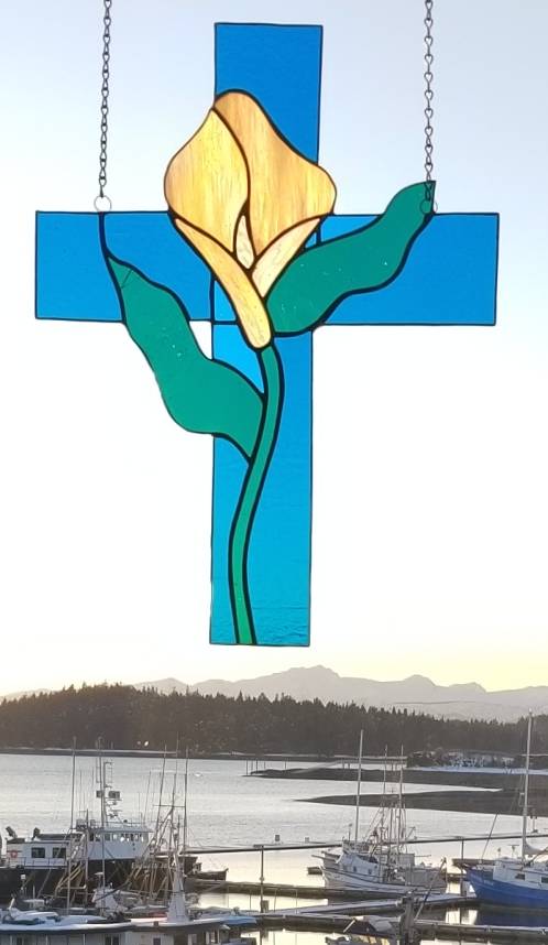 Courtesy Photo                                A stained glass cross with a lily, made from shattered glass, hangs in Shepherd of the Valley Lutheran Church overlooking Auke Bay.