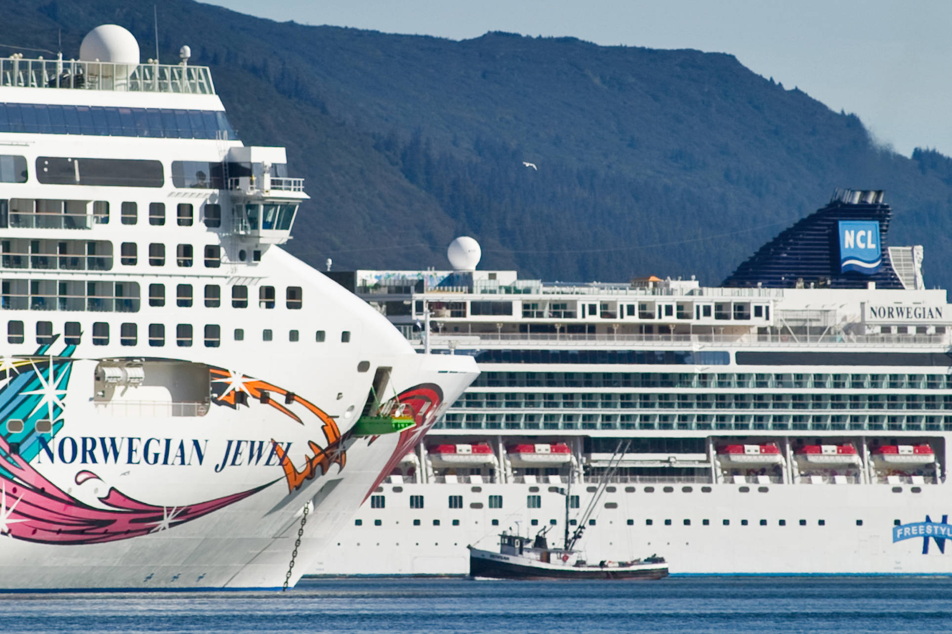 In this Sept. 9, 2014 photo, a fishing vessel is drawfed by the Norwegian Cruise Lines’ Norwegian Jewel and Norwegian Pearl in Juneau’s downtown harbor. (Michael Penn | Juneau Empire File)