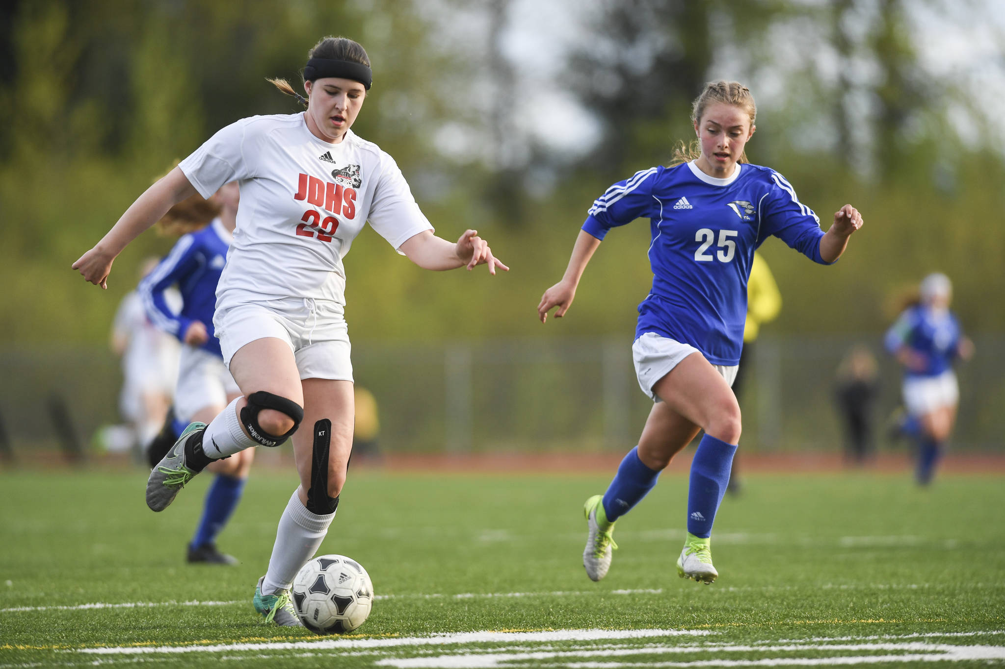 Juneau-Douglas Nikki Box, left, races against Thunder Mountains Kiah Dihle at TMHS on Tuesday, May 14, 2019. JDHS won 3-0. (Michael Penn | Juneau Empire File)