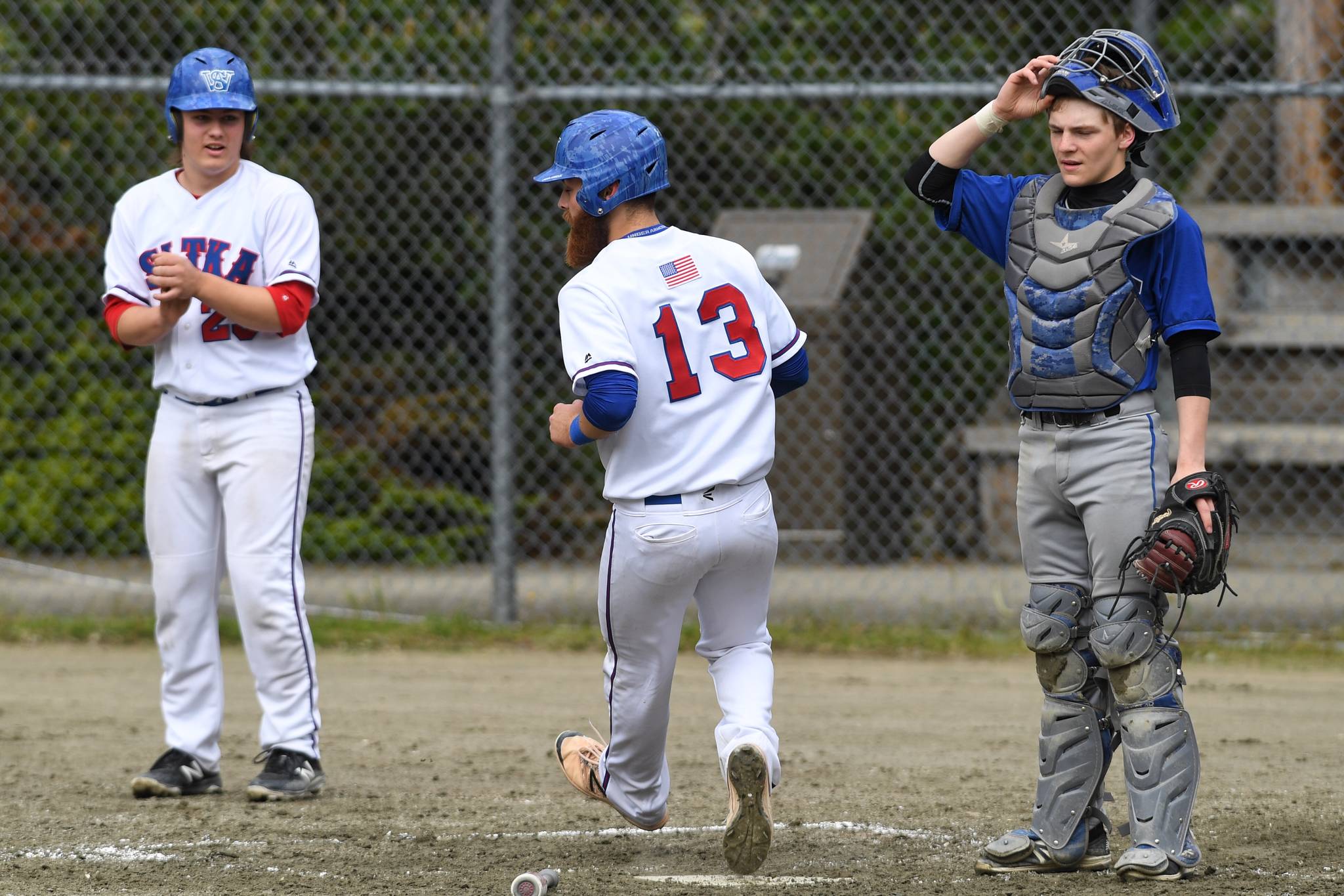 Sitka’s Isaac Roth, left, and Morgan Simic score on a dropped infield pop-up by Thunder Mountain during the Region V Baseball Championship at Adair-Kennedy Memorial Park on Friday, May 24, 2019. (Michael Penn | Juneau Empire)