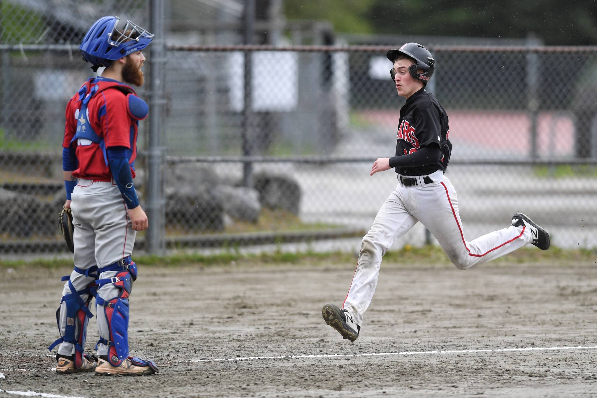 Juneau-Douglas’ Carter Walker races for home plate on a double by Luis Mojica in the second inning as Sitka’s catcher Morgan Simic waits for the ball during the Region V Baseball Championship at Adair-Kennedy Memorial Park on Thursday, May 23, 2019. (Michael Penn | Juneau Empire)