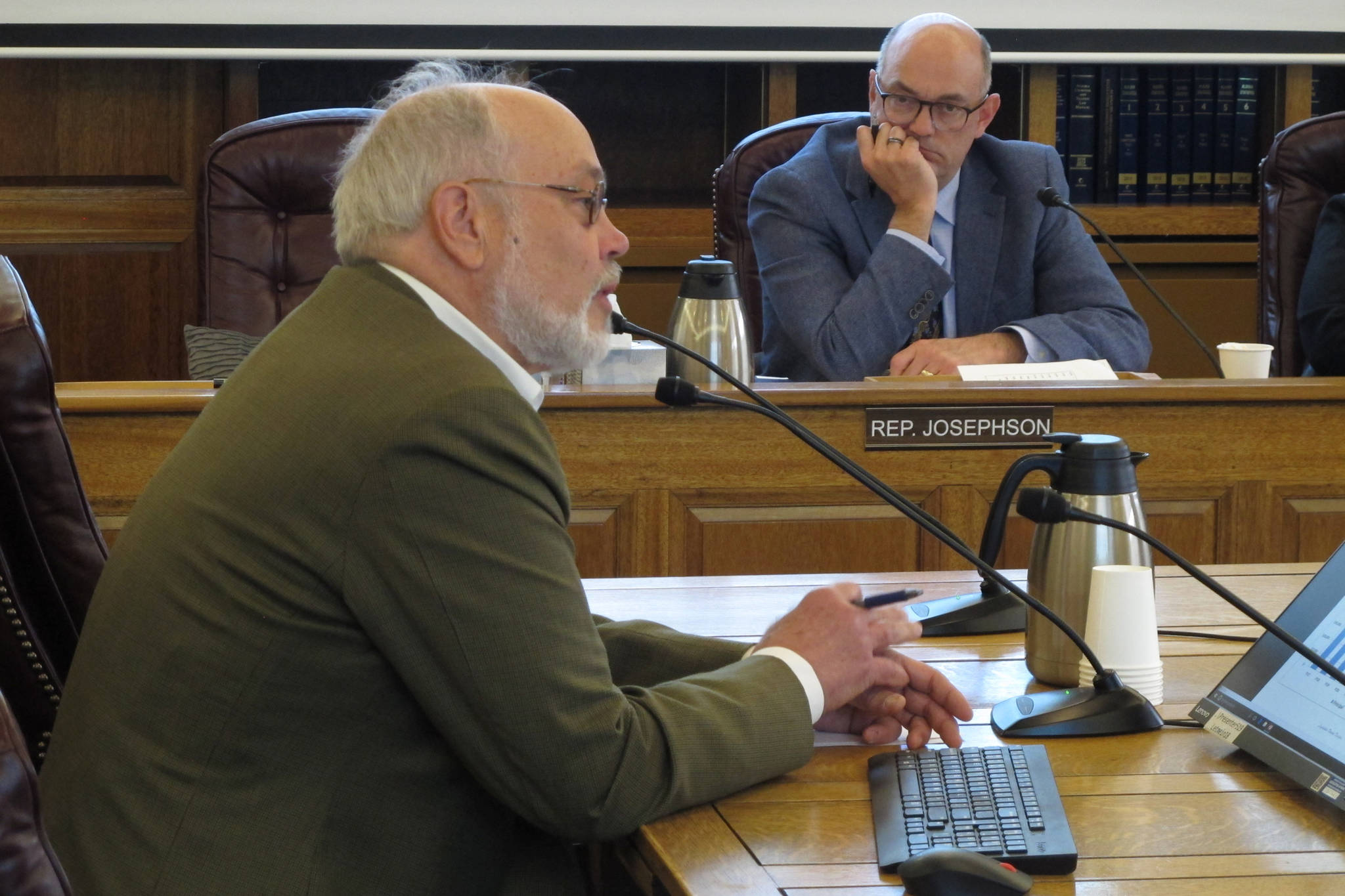 Joe Geldhof, left, testifies before the Alaska House Finance Committee on Thursday, May 23, 2019, in Juneau as Rep. Andy Josephson listens. The committee heard a bill that proposes a full Alaska Permanent Fund Dividend this year but seeks changes to the dividend formula going forward. (Becky Bohrer | Associated Press)