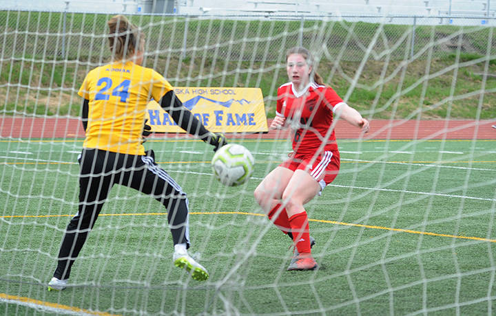 Juneau’s Eva Goering scores past Kodiak goalie Annora Virgin at the ASAA/First National Bank Alaska soccer state championships at Service High School in Anchorage on Thursday, May 23, 2019. JDHS won 6-0. (Michael Dinneen | For the Juneau Empire)