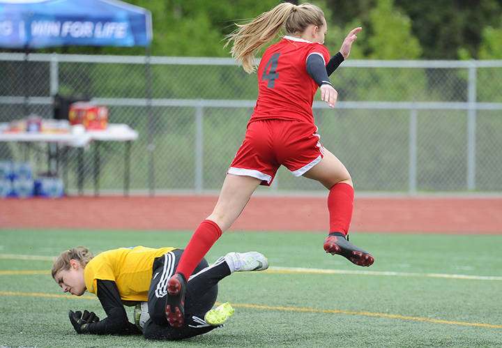 Juneau-Douglas’ Kyla Bentz leaps over Kodiak keeper Annora Virgin at the ASAA/First National Bank Alaska soccer state championships at Service High School in Anchorage on Thursday, May 23, 2019. JDHS won 6-0. (Michael Dinneen | For the Juneau Empire)