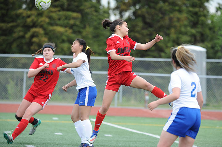 Juneau-Douglas’ Blake Plummer, right, leaps for a corner kick as teammate Nikki Box looks on and Kodiak defenders Jasmine Leiva (2) and Kyla Quiambao help defend at the ASAA/First National Bank Alaska soccer state championships at Service High School in Anchorage on Thursday, May 23, 2019. JDHS won 6-0. (Michael Dinneen | For the Juneau Empire)