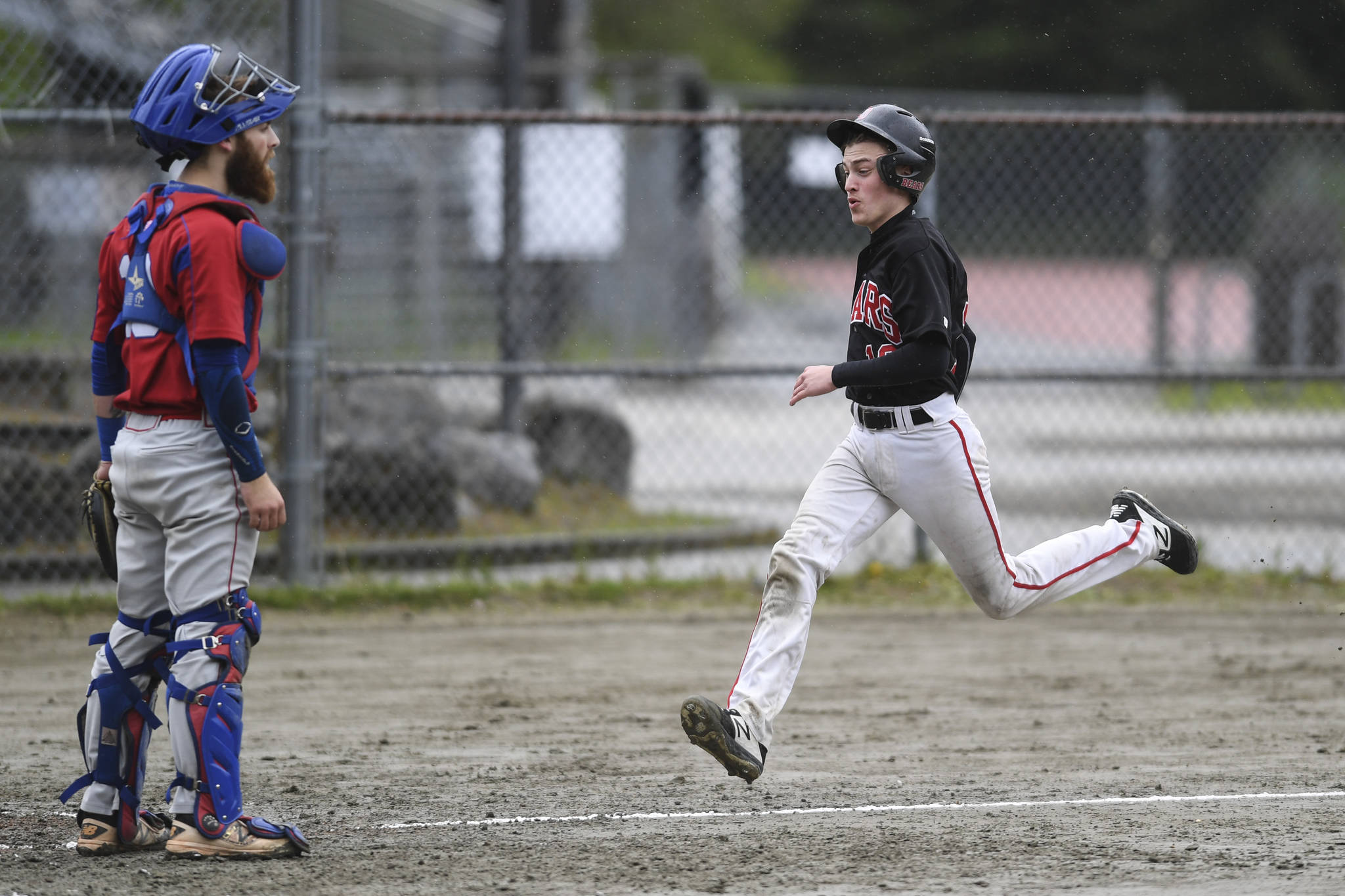 Juneau-Douglas’ Carter Walker races for home plate on a double by Luis Mojica in the second inning as Sitka’s catcher Morgan Simic waits for the ball during the Region V Baseball Championship at Adair-Kennedy Memorial Park on Thursday, May 23, 2019. JDHS won 6-5. (Michael Penn | Juneau Empire)