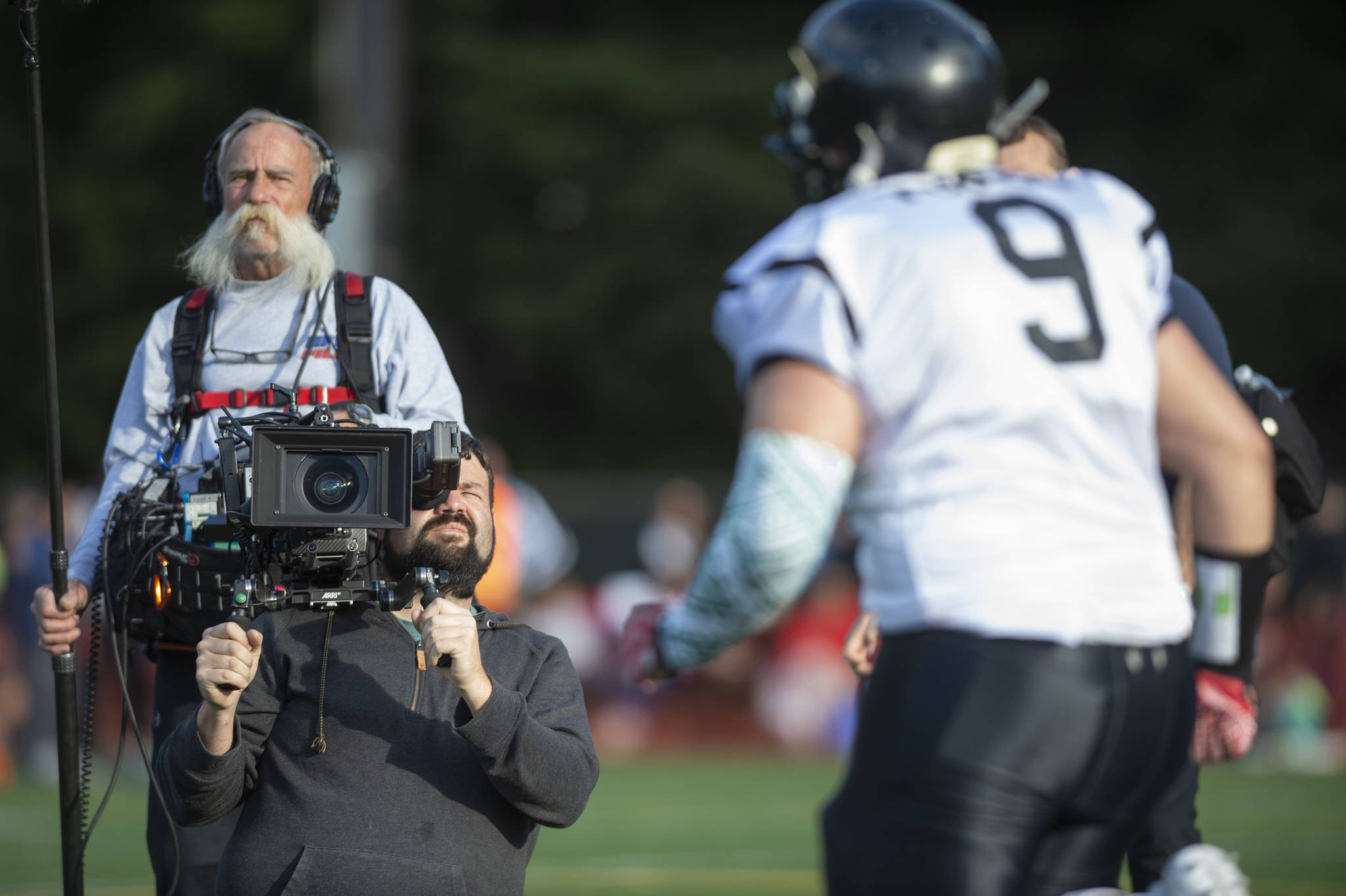 A video crew from NFL Films documents the Juneau Alumni Football Game with football players, dance team members and cheerleaders from Juneau-Douglas and Thunder Mountain High Schools at Adair-Kennedy Memorial Field on Friday, May 24, 2019. (Michael Penn | Juneau Empire)