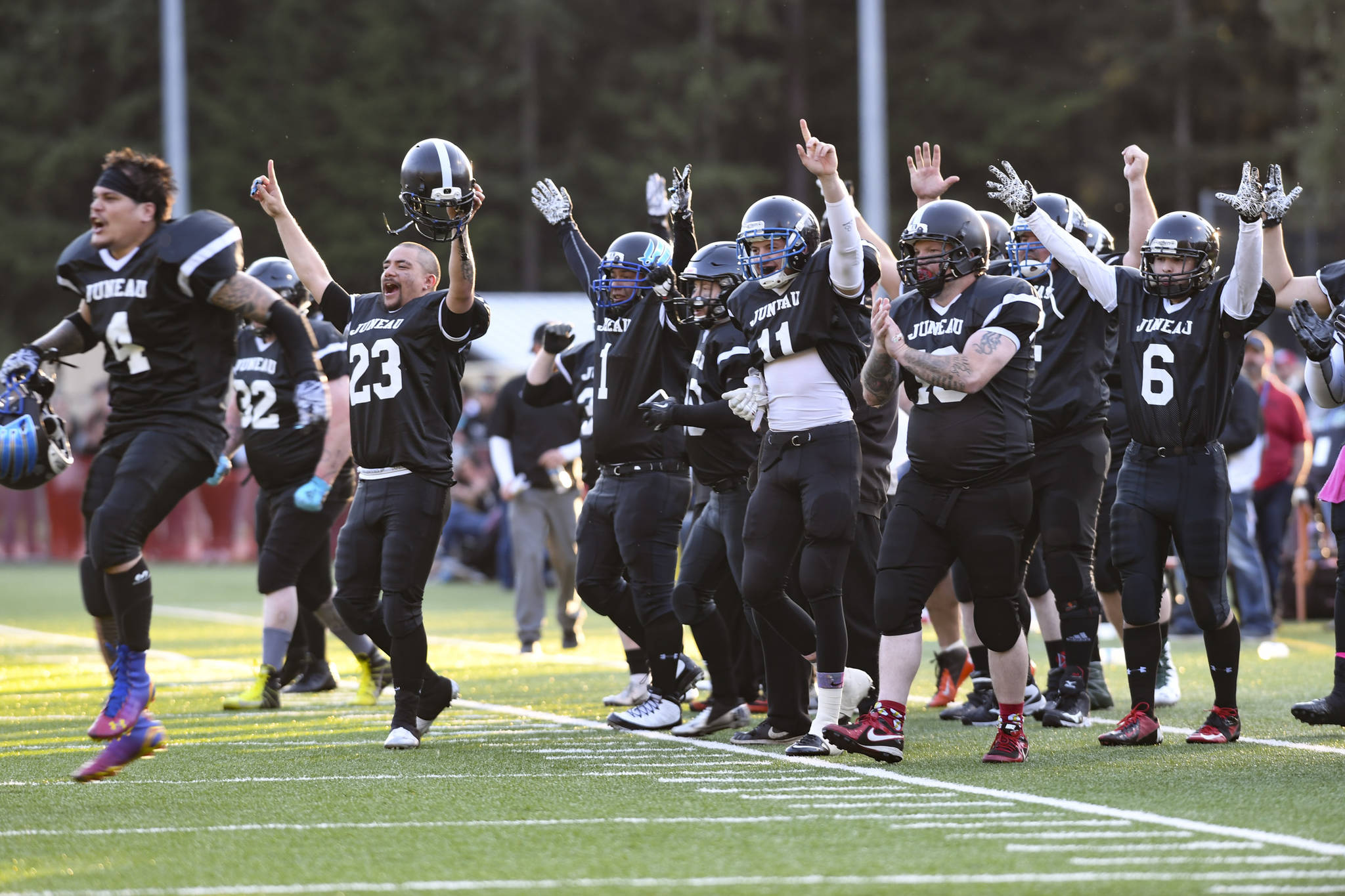 Legends players celebrate their first touchdown at the Juneau Alumni Football Game with football players, dance team members and cheerleaders from Juneau-Douglas and Thunder Mountain High Schools at Adair-Kennedy Memorial Field on Friday, May 24, 2019. (Michael Penn | Juneau Empire)