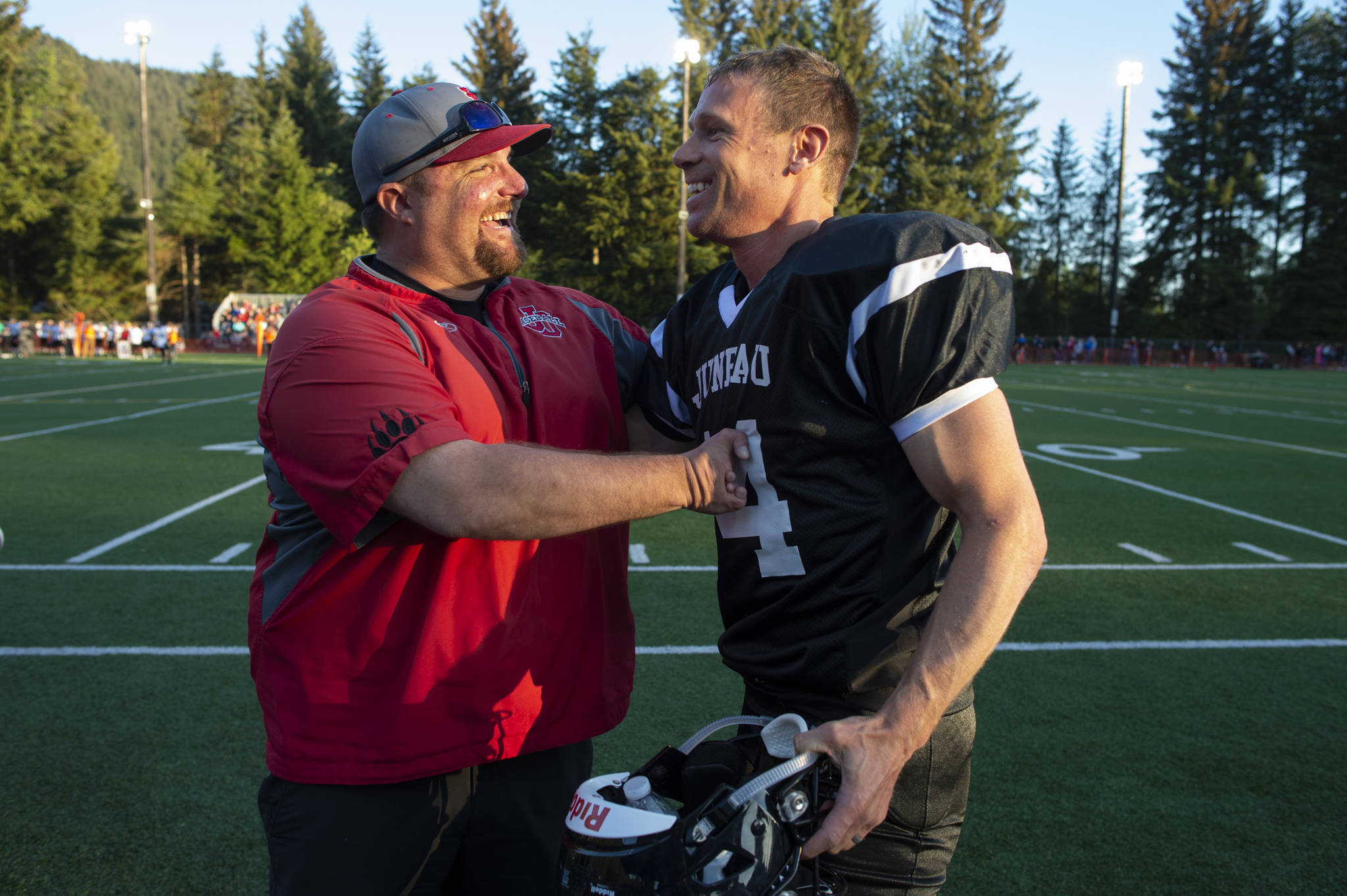 Chad Bentz congratulates Legends’ Josh Dean on his touchdown during the Juneau Alumni Football Game with football players, dance team members and cheerleaders from Juneau-Douglas and Thunder Mountain High Schools at Adair-Kennedy Memorial Field on Friday, May 24, 2019. (Michael Penn | Juneau Empire)
