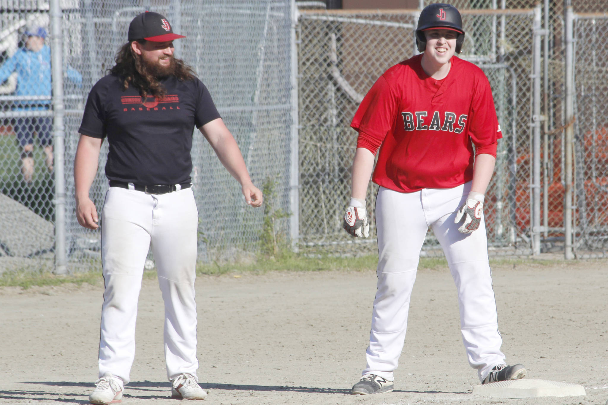 Juneau-Douglas High School: Yadaa.at Kale player Christian Ludeman gets a fist bump from coach Chris Dillon after advancing to third on a single and an error during the Region V title game against Ketchikan on Saturday, May 25, 2019. (Alex McCarthy | Juneau Empire)