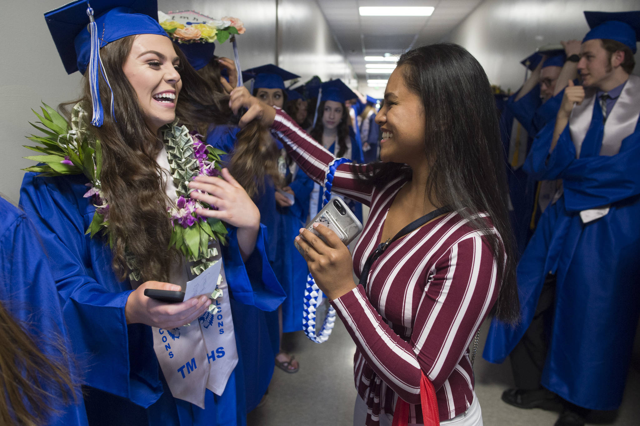 Heilala Toetuu, right, delivers a lay to senior Anna Parise before the Thunder Mountain High School graduation on Sunday, May 26, 2019. (Michael Penn | Juneau Empire)