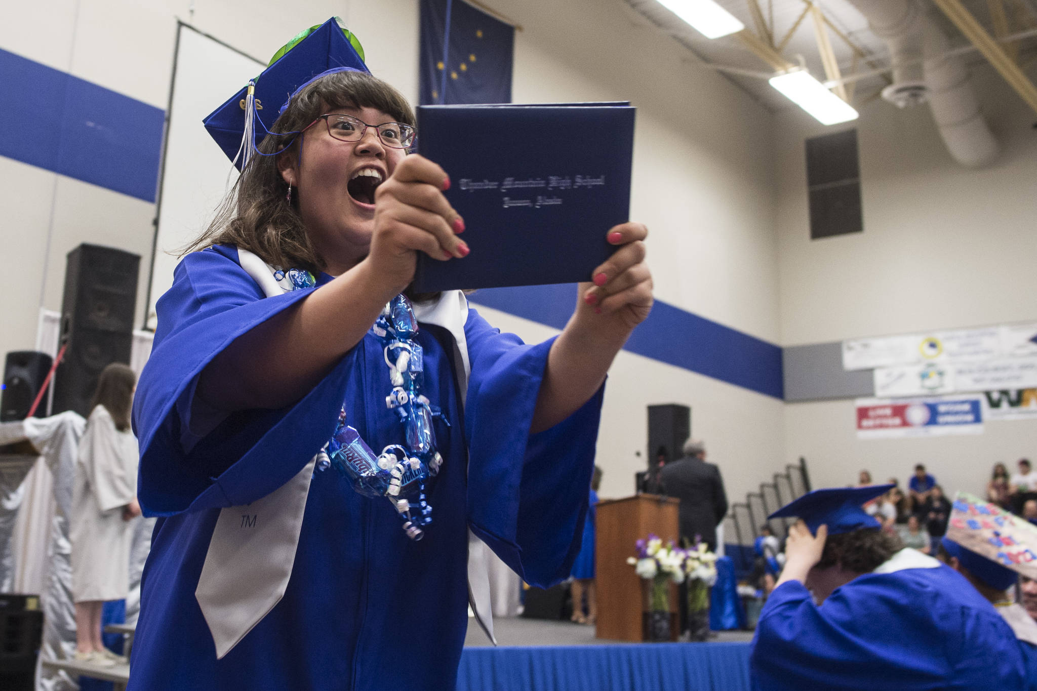 Jennifer Pyeatt reacts to receiving her diploma after walking off the stage during the Thunder Mountain High School graduation on Sunday, May 26, 2019. (Michael Penn | Juneau Empire)