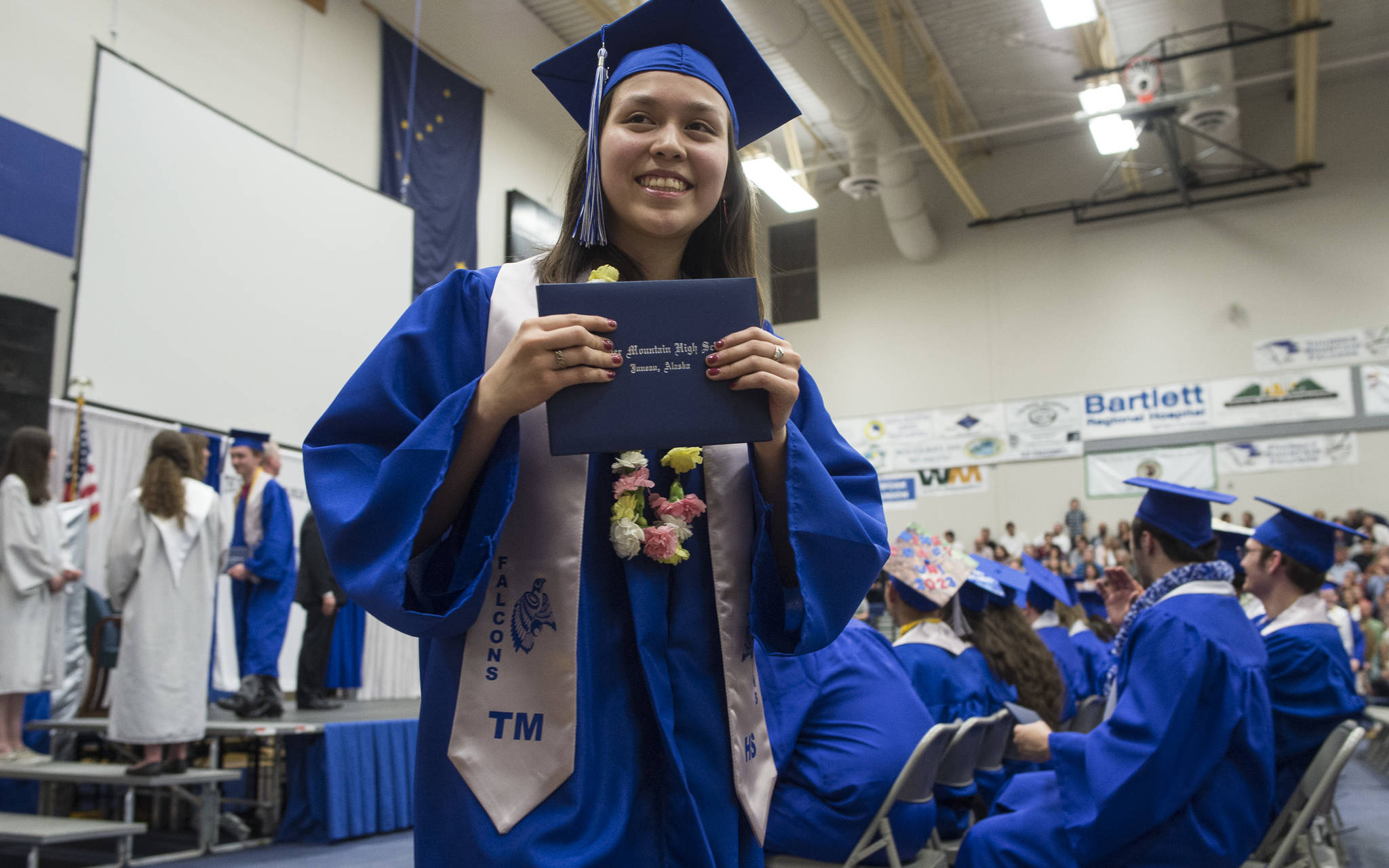 Adindean Franklin displays her diploma for her family after walking off the stage during the Thunder Mountain High School graduation on Sunday, May 26, 2019. (Michael Penn | Juneau Empire)