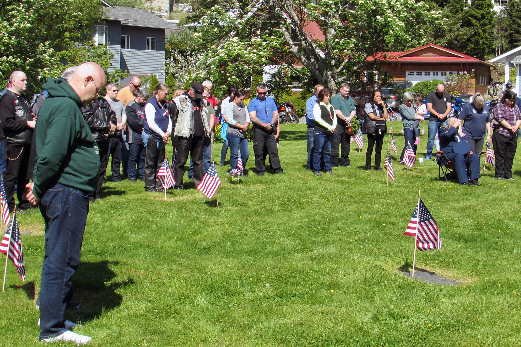 Attendees bow their heads during prayer at a Memorial Day Ceremony held at Evergreen Cemetery, Monday, May 27. (Ben Hohenstatt | Juneau Empire)