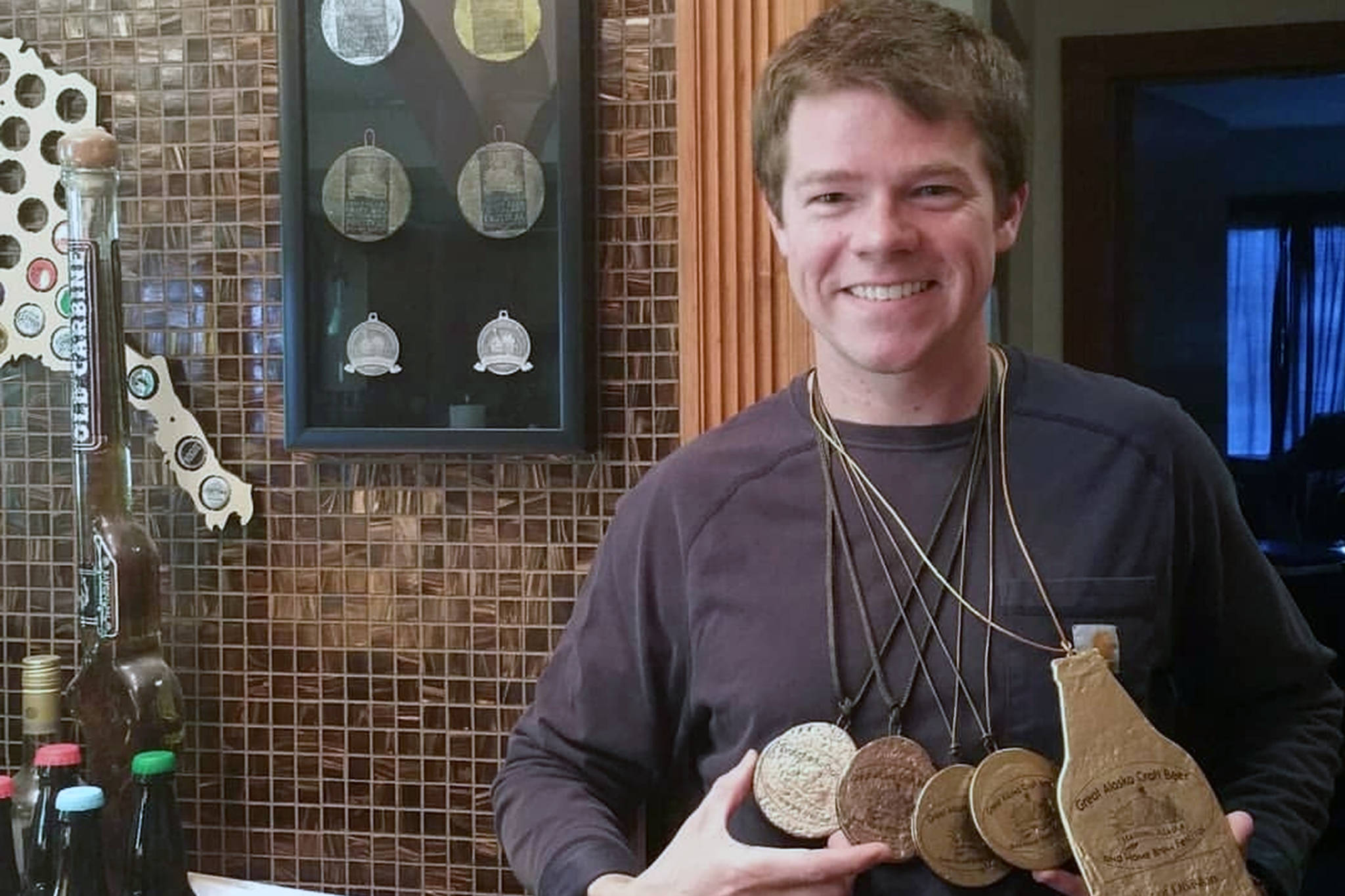 David Howard, who placed in multiple categories at Great Alaska Craft Beer and Homebrew Festival, shows off medals he’s won in past festivals. (Courtesy Photo | Alexis Howard)