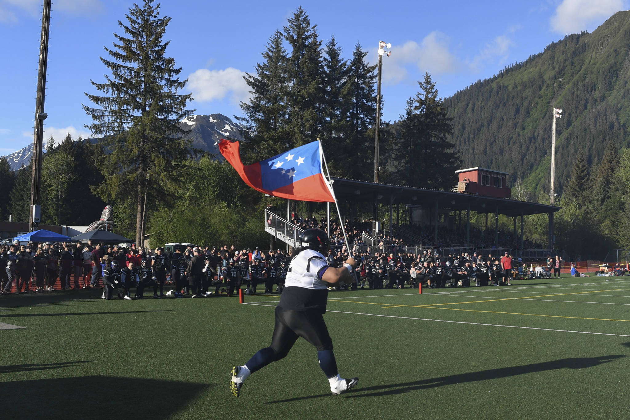 Juneau Stars’ Lino Fenumiai, a graduate of 2000, enters the field for the Juneau Alumni Football Game with football players, dance team members and cheerleaders from Juneau-Douglas and Thunder Mountain High Schools at Adair-Kennedy Memorial Field on Friday, May 24, 2019. (Michael Penn | Juneau Empire File)
