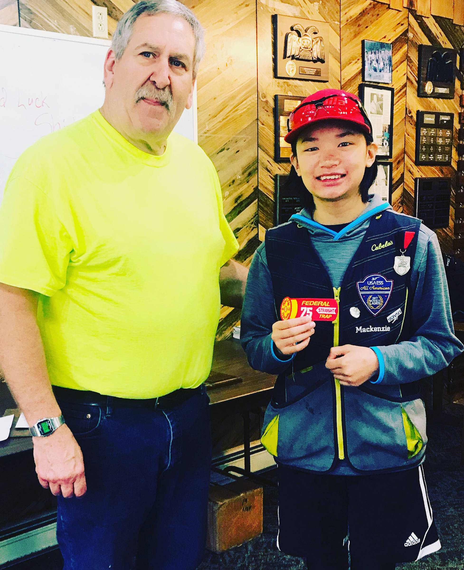 Juneau Gun Club President Jerry Godkin presents Mackenzie Lam with a 75 Trap Patch, awarded to individuals who hit 75 straight targets. (Courtesy Photo | Marie Lam)