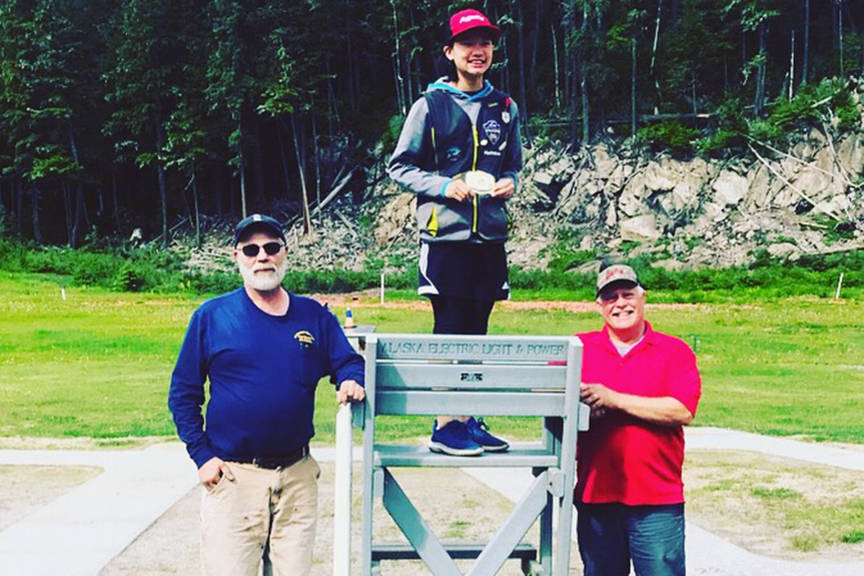 Juneau Trap Team’s Mackenzie Lam, center, stands on a makeshift podium after defeating Fairbanks Trap Club’s Pete Hudson, left, and Brian “Stubby” Hughes in the handicap shoot, one of four events that comprised the Spring Shoot at the Juneau Gun Club last weekend. (Courtesy Photo | Marie Lam)