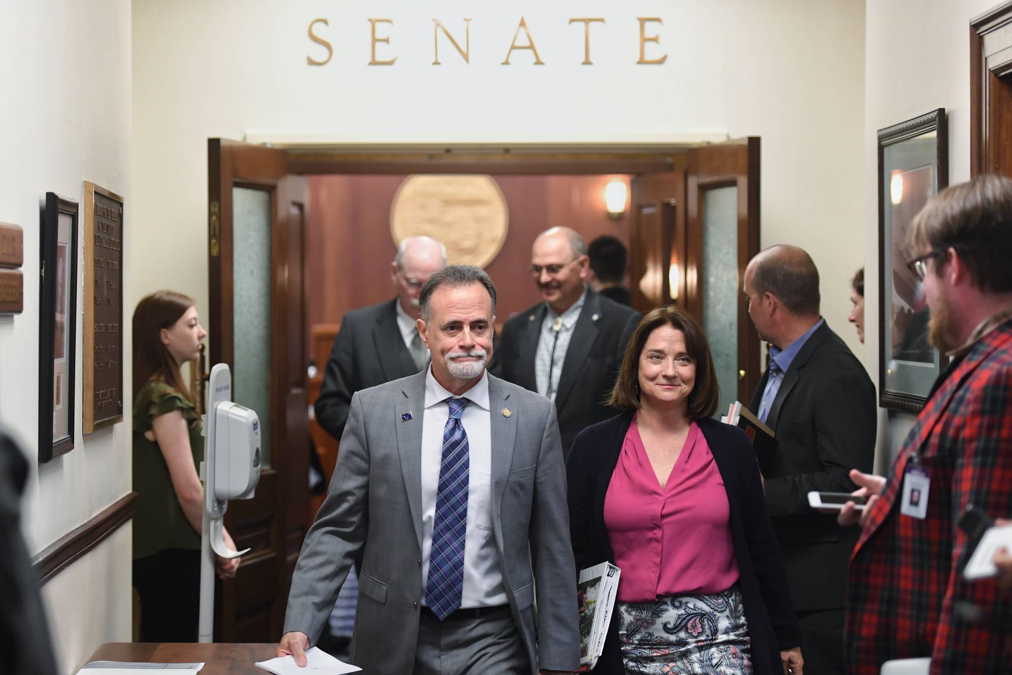Senators Peter Micciche, R-Soldotna, and Lora Reinbold, R-Eagle River, walk out of the Senate chambers with other senators after a “call” on the Senate was lifted on Thursday, June 6, 2019. (Michael Penn | Juneau Empire)