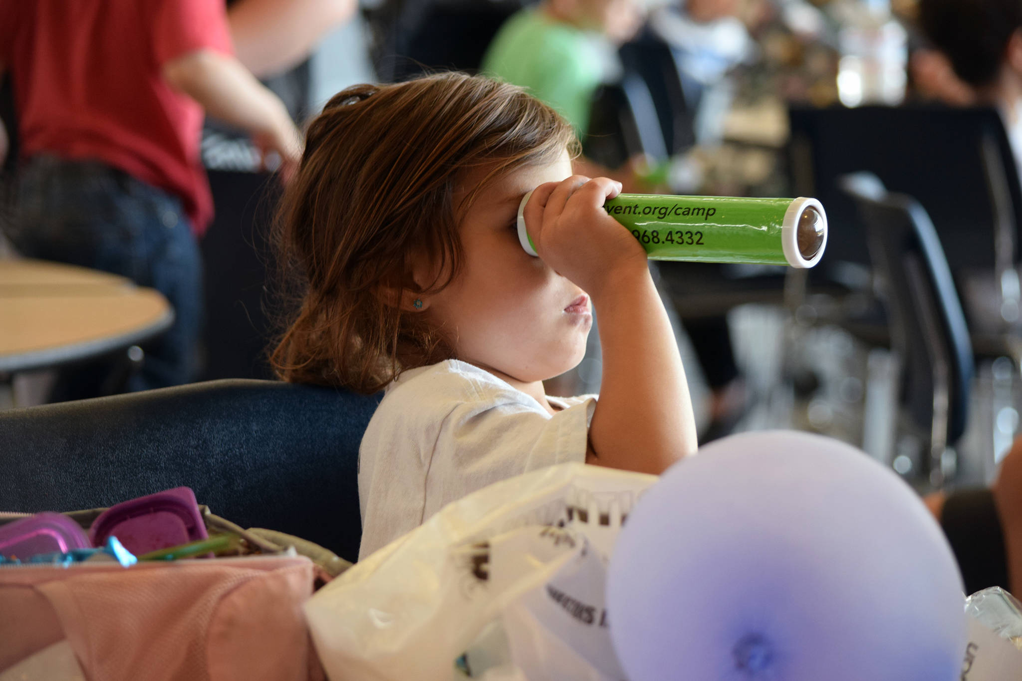Kaelynn Beedle, 5, looks into a kaleidoscope during the Camp Invention showcase at Thunder Mountain High School, Friday June 7, 2019. (Ben Hohenstatt | Juneau Empire)