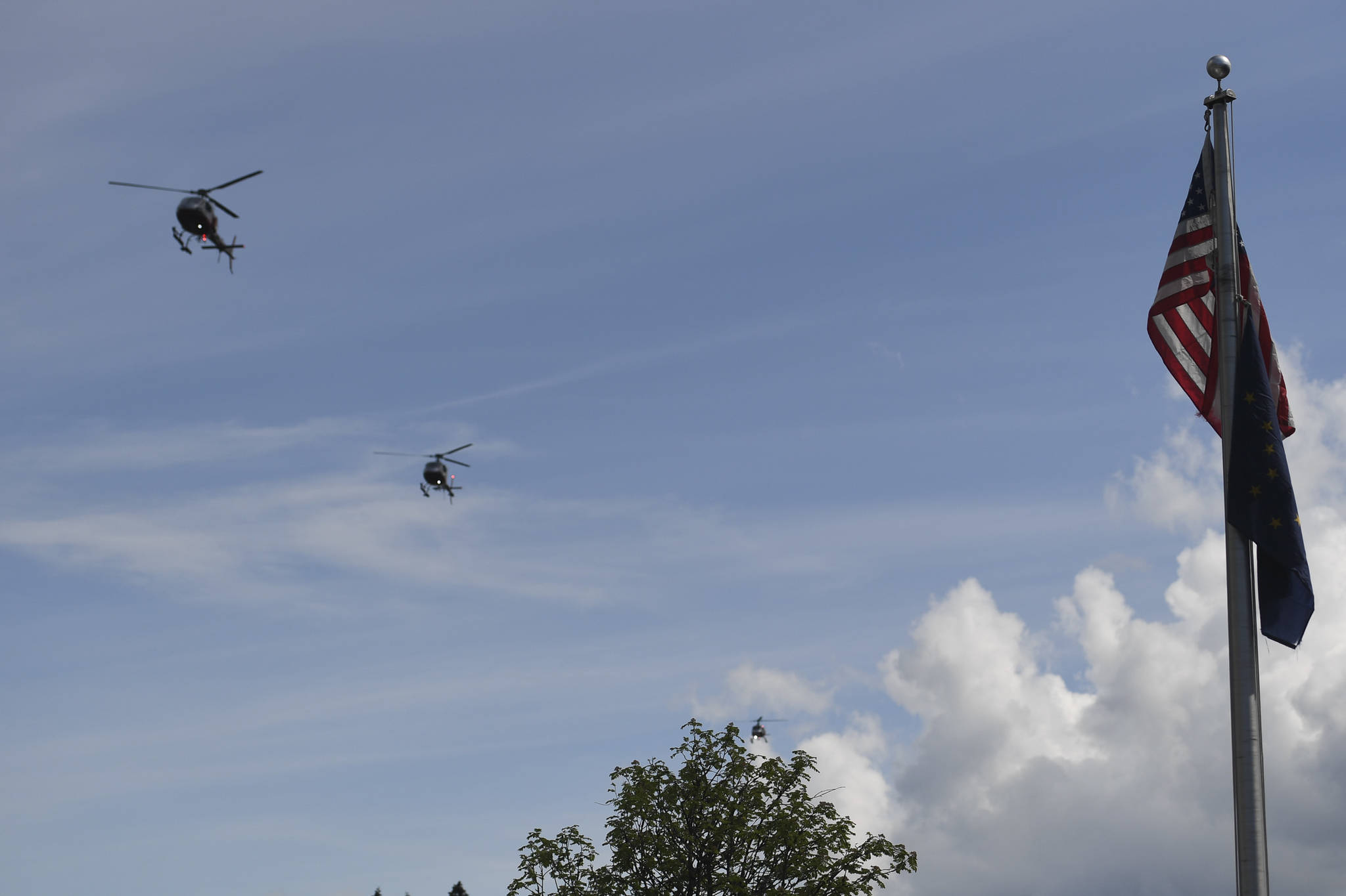 Three helicopters make a flyover at the end of a memorial service for the Guardian Flight crew is held at Juneau-Douglas High School: Yadaa.at Kalé on Friday, June 7, 2019. (Michael Penn | Juneau Empire)