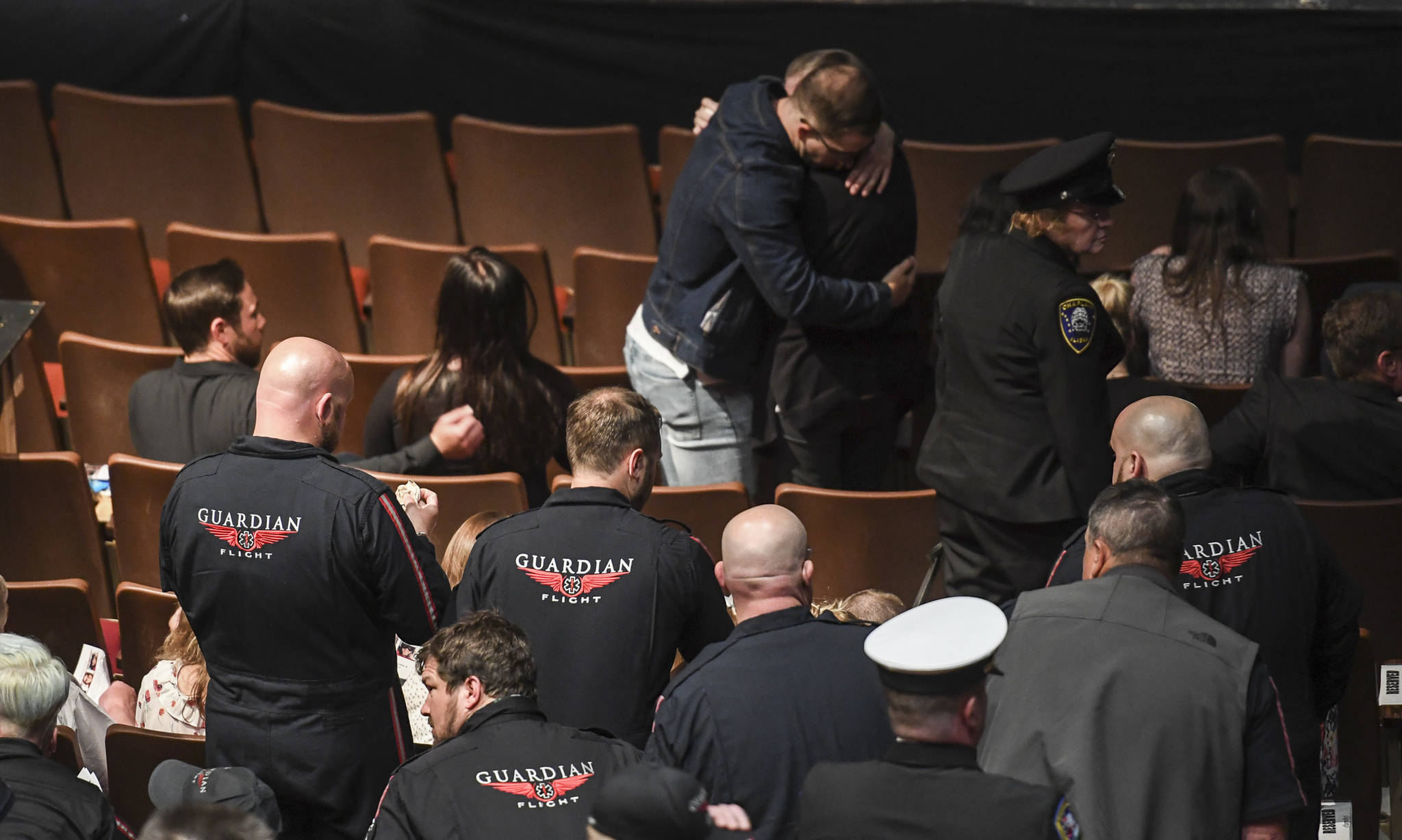 Family members embrace at the end of the a memorial service for the Guardian Flight crew held at Juneau-Douglas High School: Yadaa.at Kalé on Friday, June 7, 2019. (Michael Penn | Juneau Empire)
