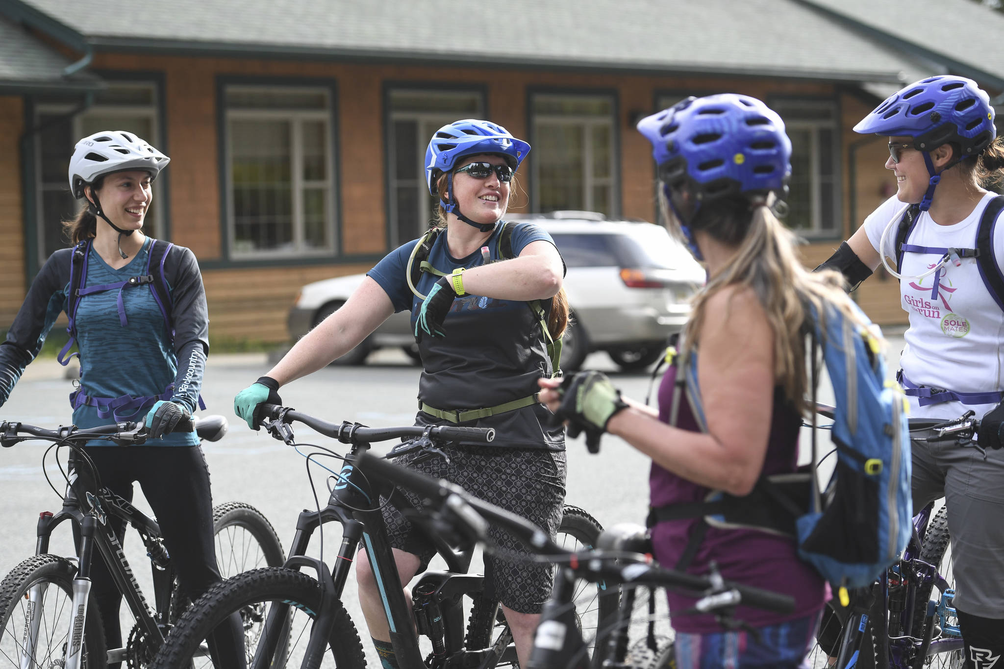 Briana Swanson, second from left, President of the Juneau Mountain Bike Alliance, speaks before leading a women’s mountain bike ride at Dredge Lakes on Thursday, June 13, 2019. (Michael Penn | Juneau Empire)