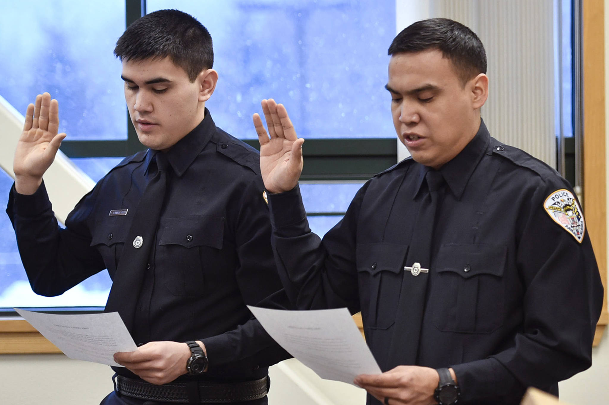 Jonah Hennings-Booth, of Eagle River, left, and Duain White, of Juneau, are sworn in during a ceremony at the Juneau Police Department station on Thursday, Feb. 21, 2019. (Michael Penn | Juneau Empire File)