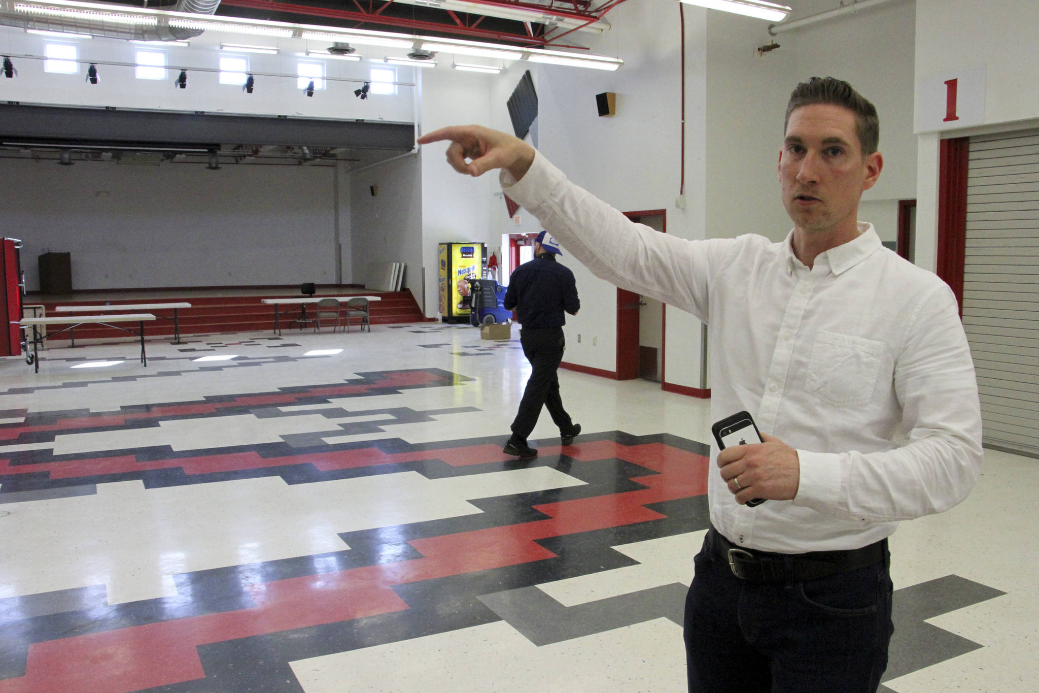 This June 14, 2019, photo shows Jeremy Price, a deputy chief of staff to Alaska Gov. Mike Dunleavy, showing reporters the cafeteria at Wasilla Middle School in Wasilla, Alaska, that would be available to lawmakers. Dunleavy has called lawmakers into special session in Wasilla beginning July 8, but some lawmakers have expressed concerns over security and logistics with the location more than 500 miles from the state capital of Juneau, Alaska. (AP Photo/Mark Thiessen)