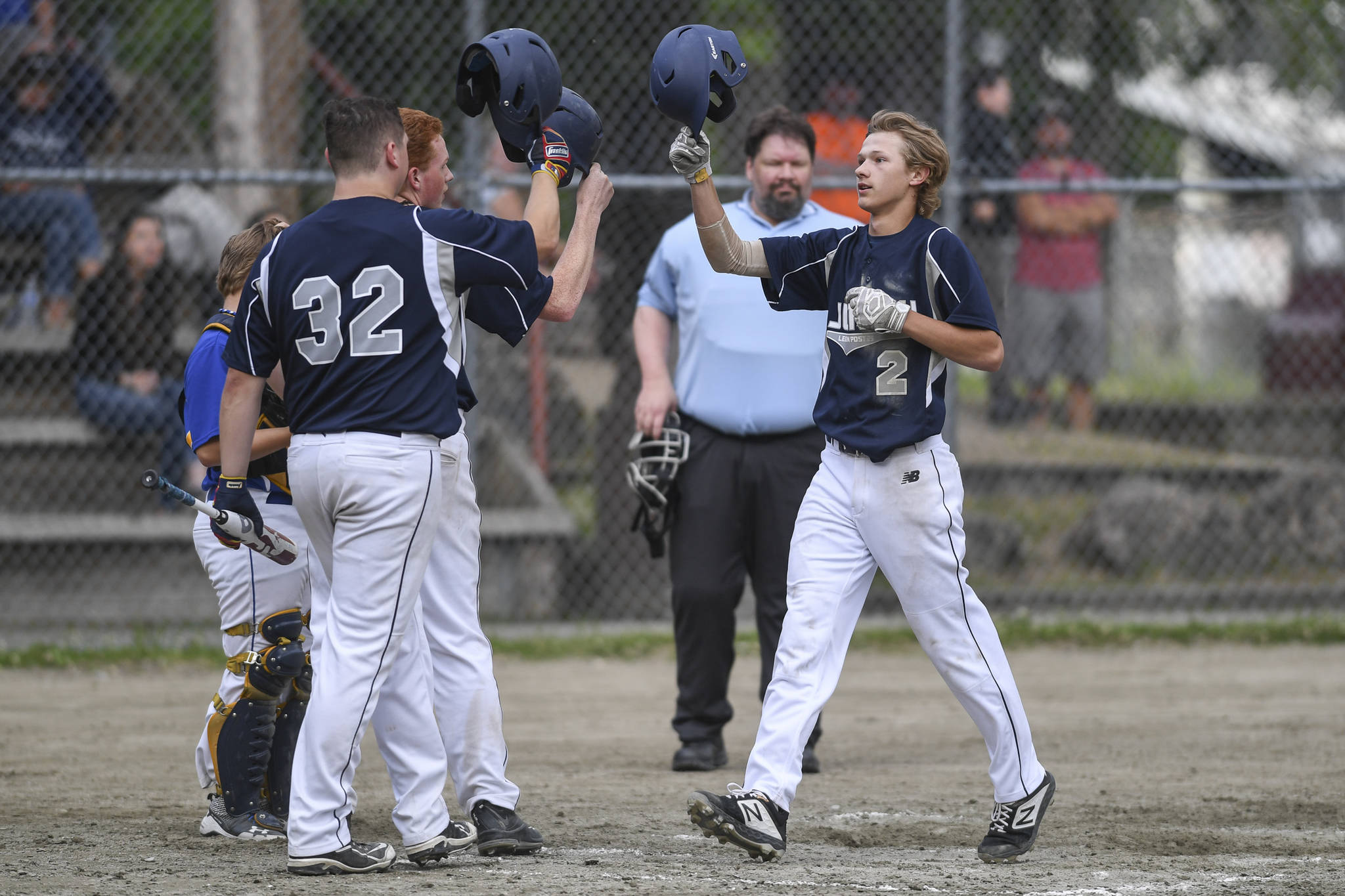 Juneau’s Gabe Storie, right, touches helmets with teammate Robert Cox and Luke Mallinger after hitting a two run homer in the fourth inning against Bartlett in Legion League baseball at Adair-Kennedy Memorial Park on Friday, June 21, 2019. (Michael Penn | Juneau Empire)