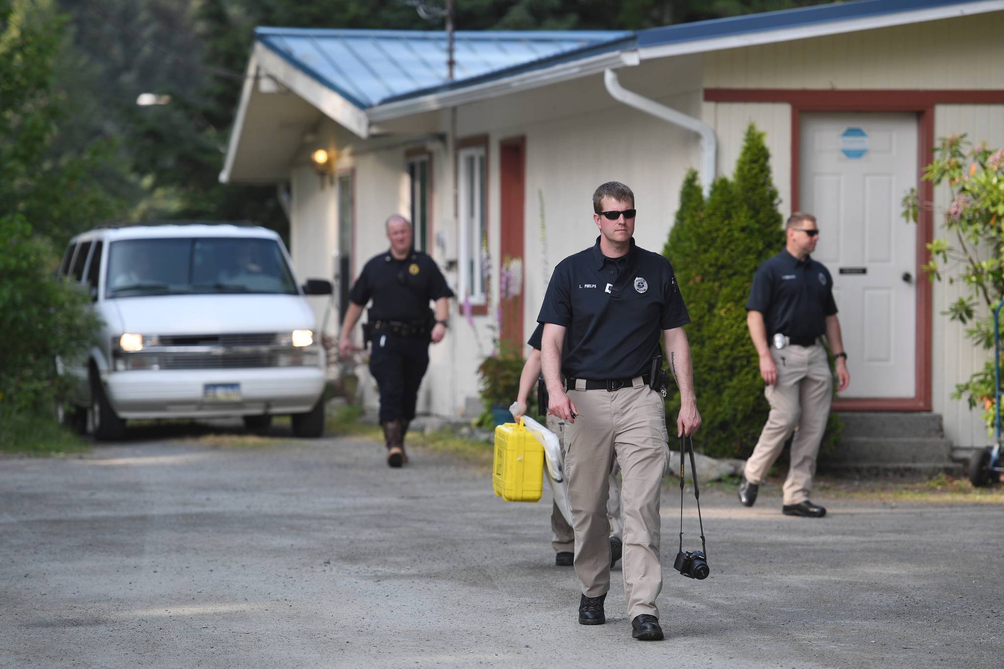 JPD detectives leave 9010 Atlin Drive as a body is driven away on Wednesday, July 3, 2019. (Michael Penn | Juneau Empire)