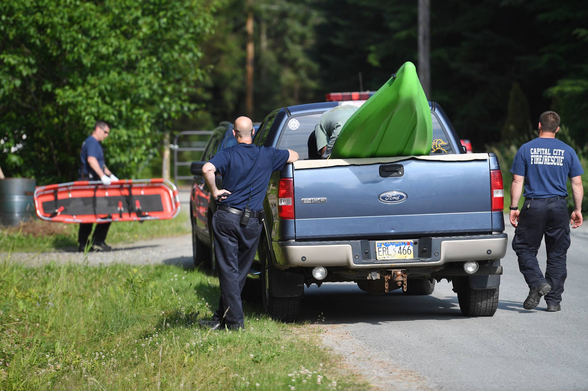 Capital City Fire/Rescue personnel pack up after helping the Juneau Police Department recover a body found in a pond behind 9010 Atlin Drive on Wednesday, July 3, 2019. (Michael Penn | Juneau Empire)